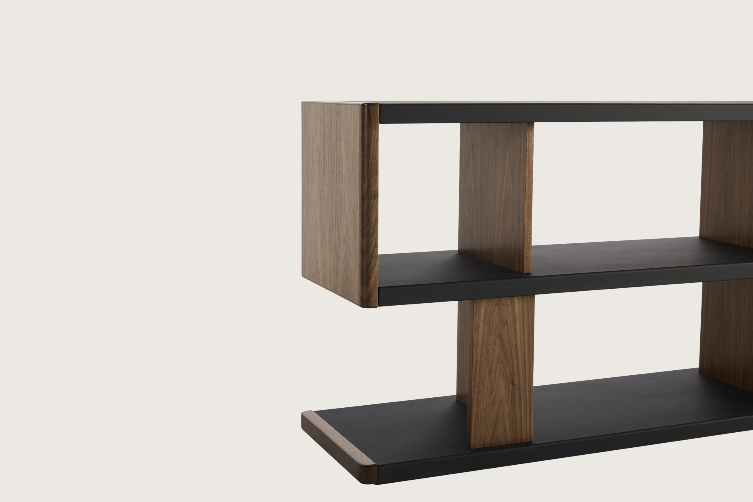 Detail shot of New Canaan Low Bookshelf designed by BassamFellows for Geiger in Walnut with Black Leather shown angled on a white sweep.