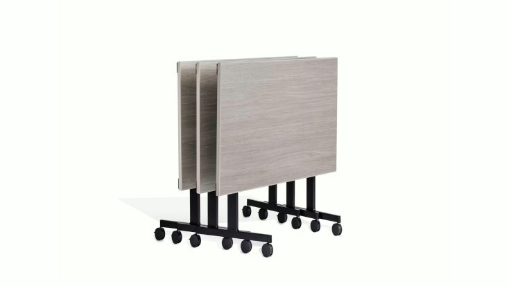 Stacked rectangular Pixel C-Leg Tables by Knoll with light wood tops and black metal bases on casters.