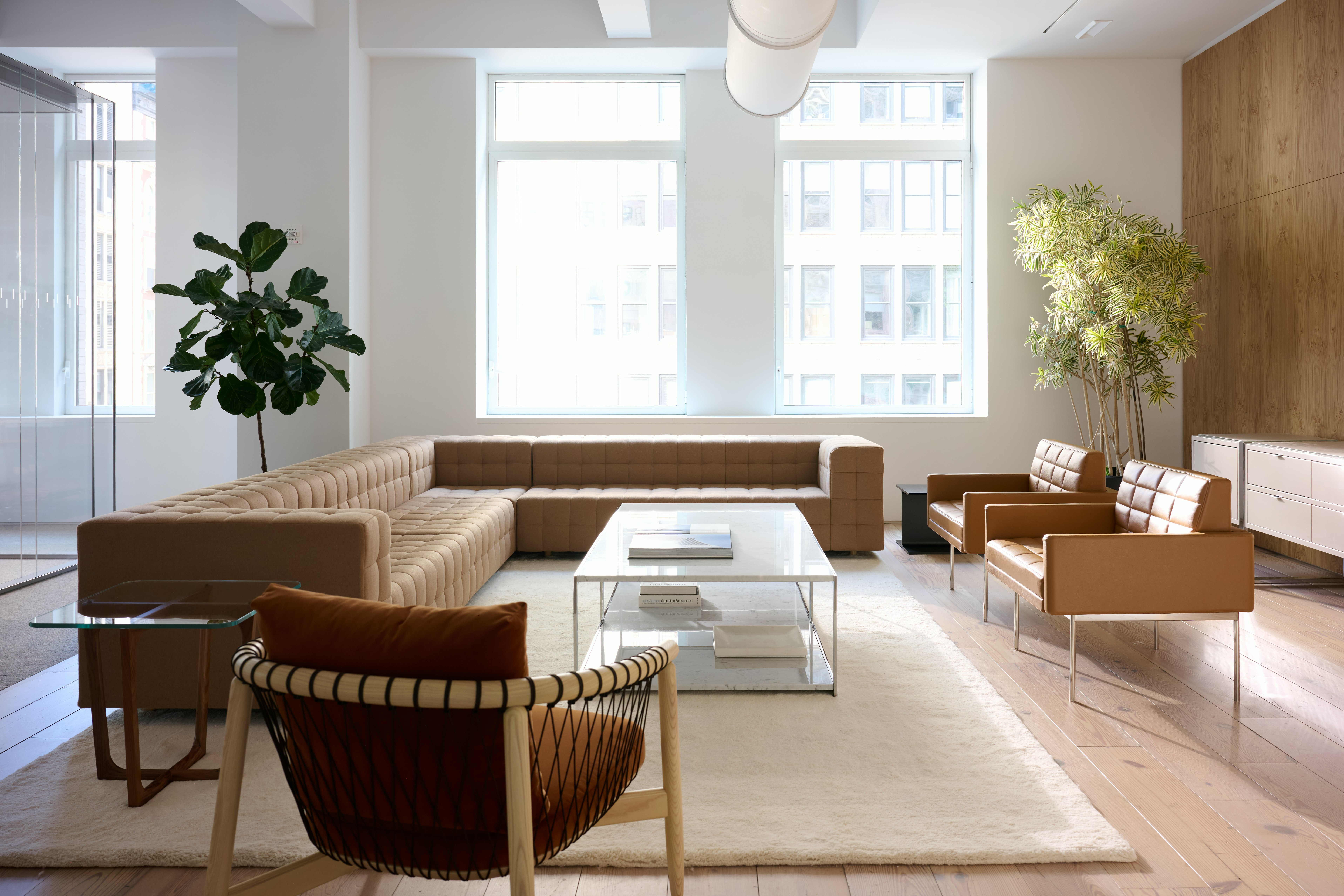 Lounge setting with a Rapport Sectional Sofa, Tuxedo Component Club Chairs, and Crosshatch Lounge Chair around two H-Frame Coffee Tables. 