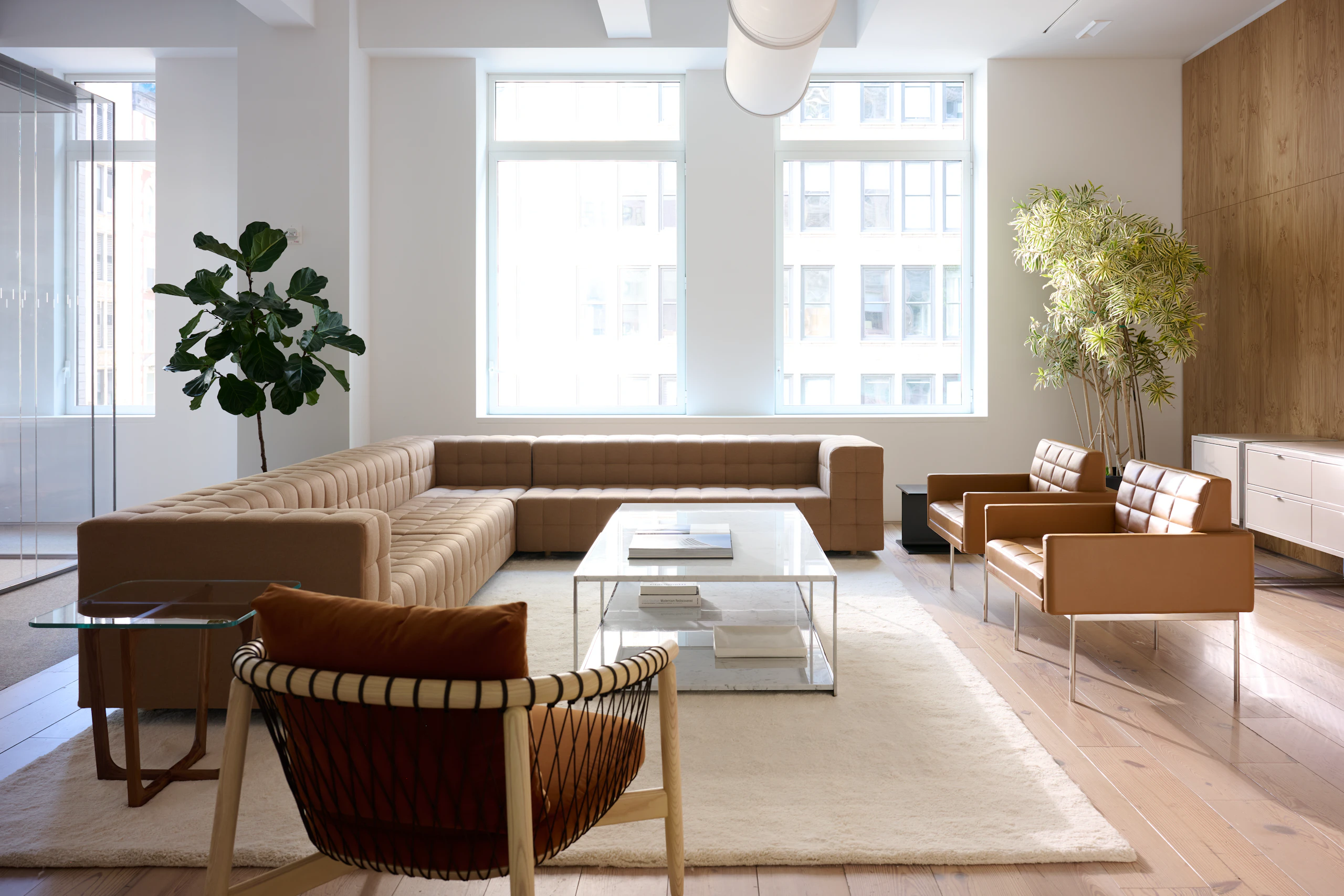 Lounge setting with a Rapport Sectional Sofa, Tuxedo Component Club Chairs, and Crosshatch Lounge Chair around two H-Frame Coffee Tables.