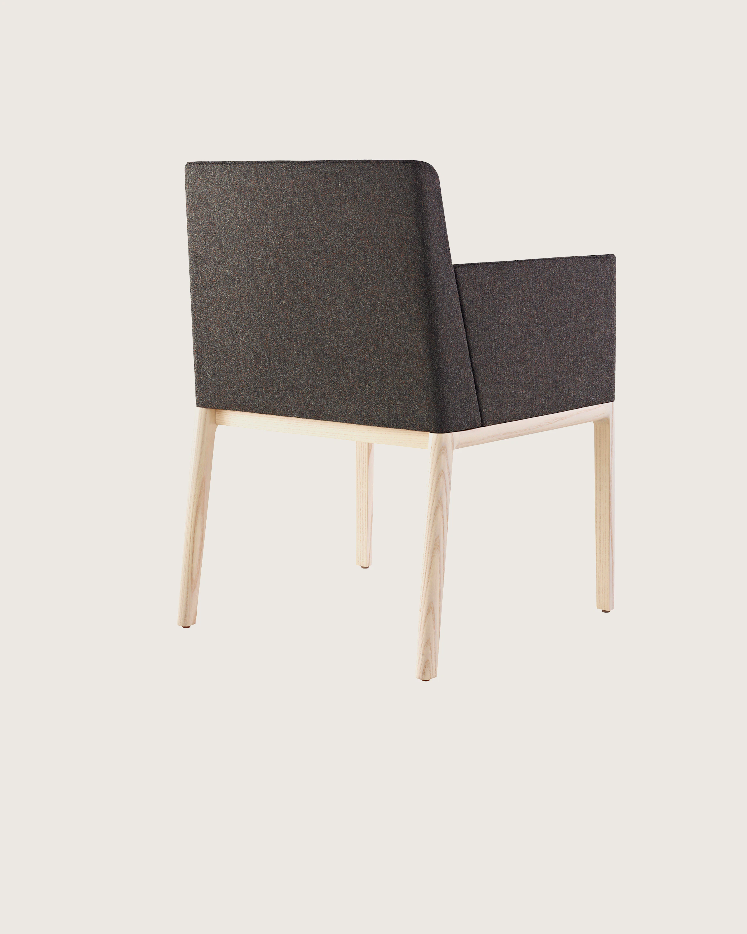 A Nessel side chair with black fabric upholstery, wraparound arms, and a wood frame with a light finish, viewed from behind at an angle.