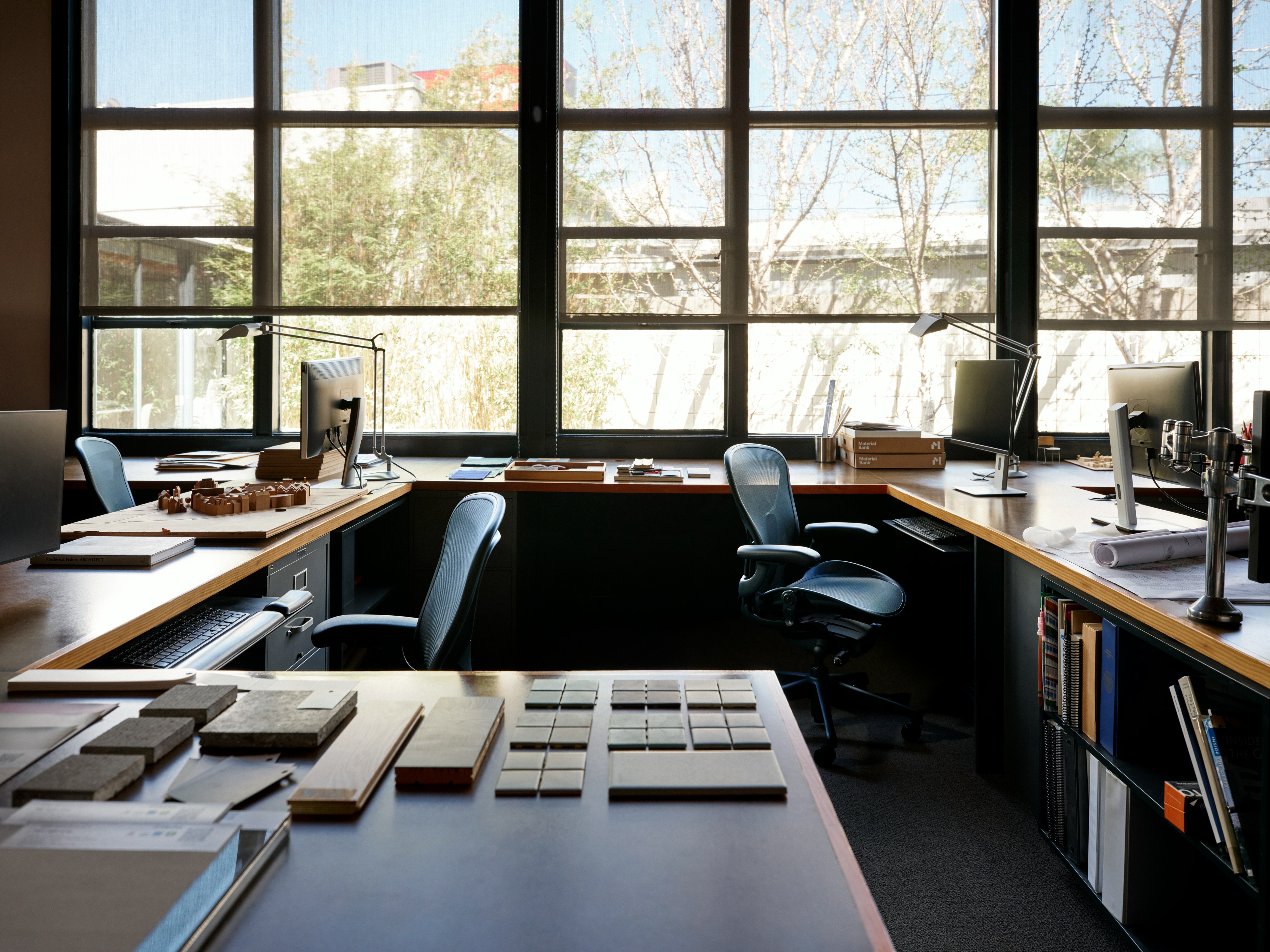 Two Aeron Chairs in dark blue surrounded by multiple desks in an office.
