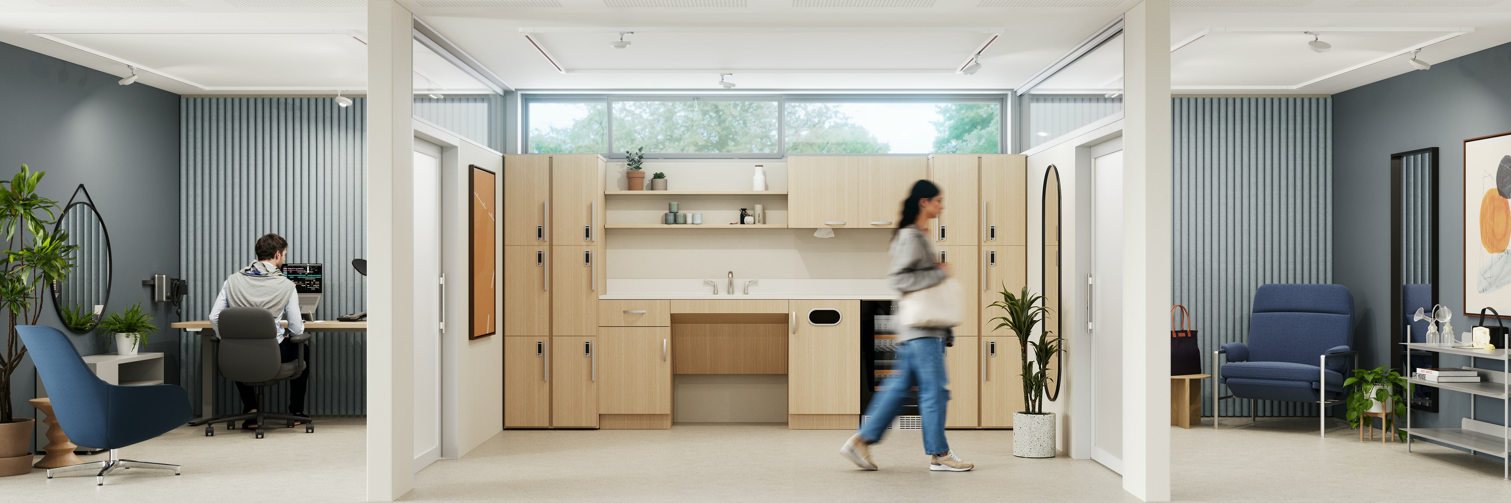 Woman walking through a communal kitchenette space into a private wellness room furnished with a blue side chair, side table, and potted plant.