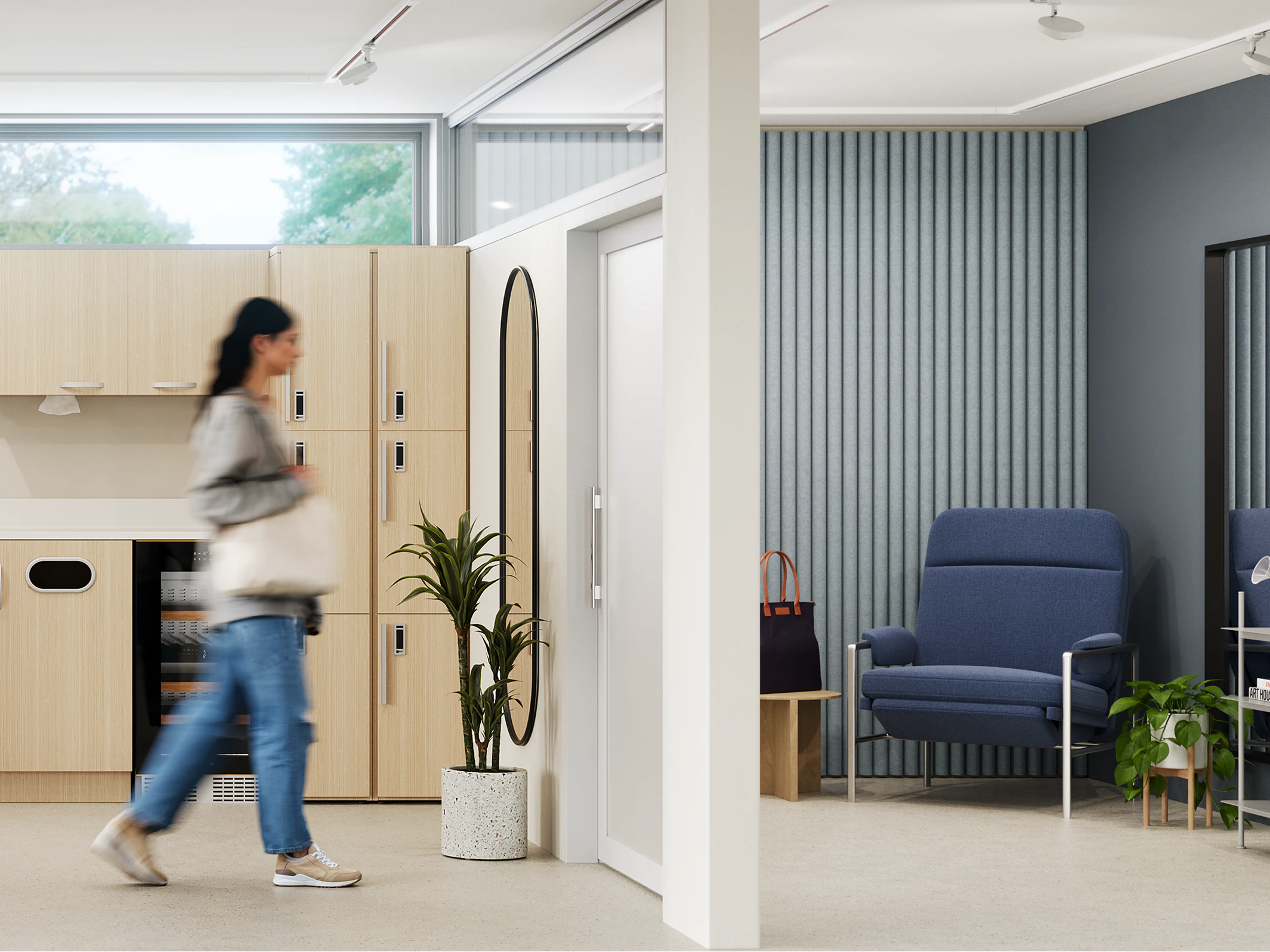 Woman walking through a communal kitchenette space into a private wellness room furnished with a blue side chair, side table, and potted plant.