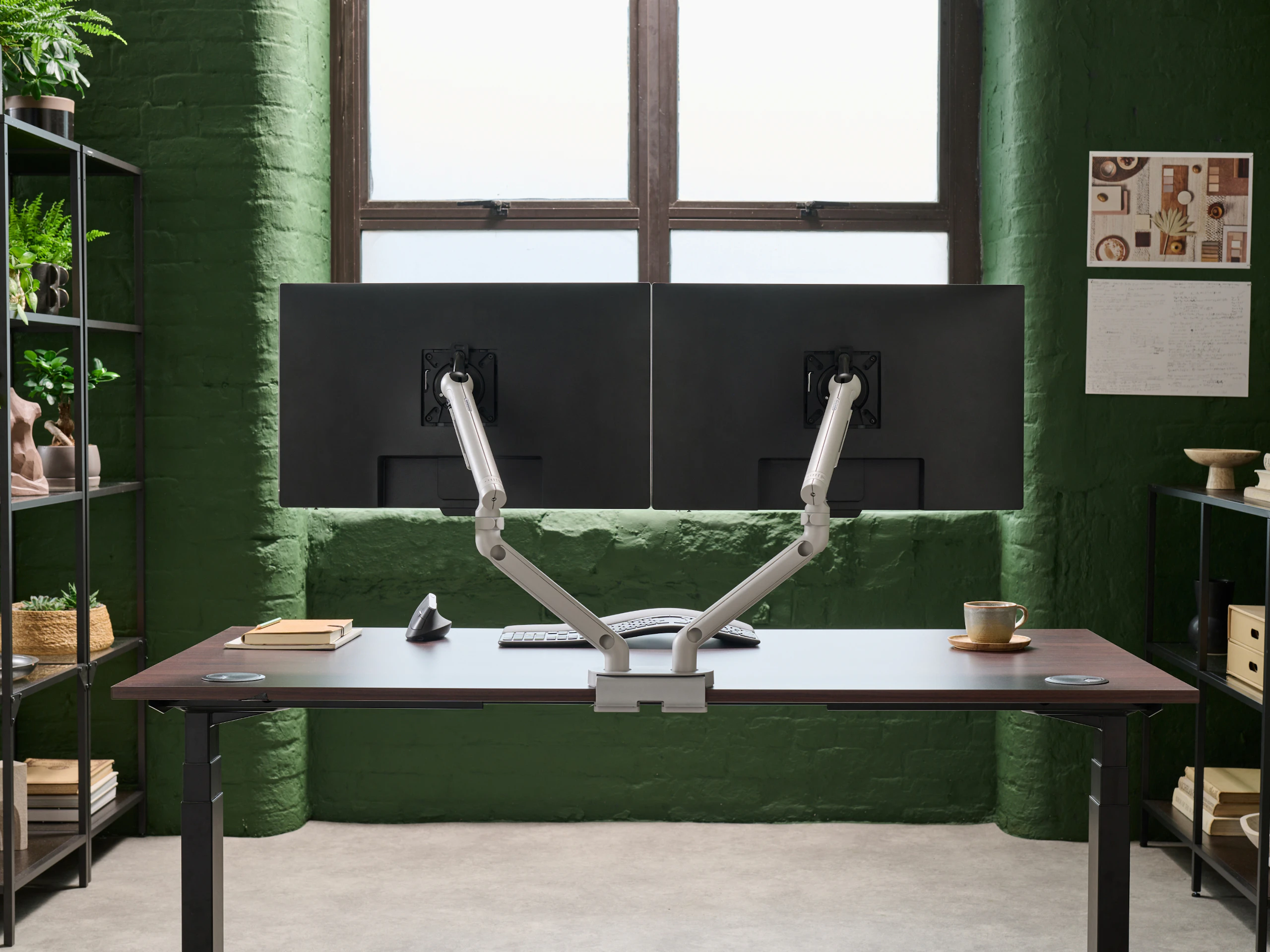Desk with silver Flo Dual monitor arm in a working environment.