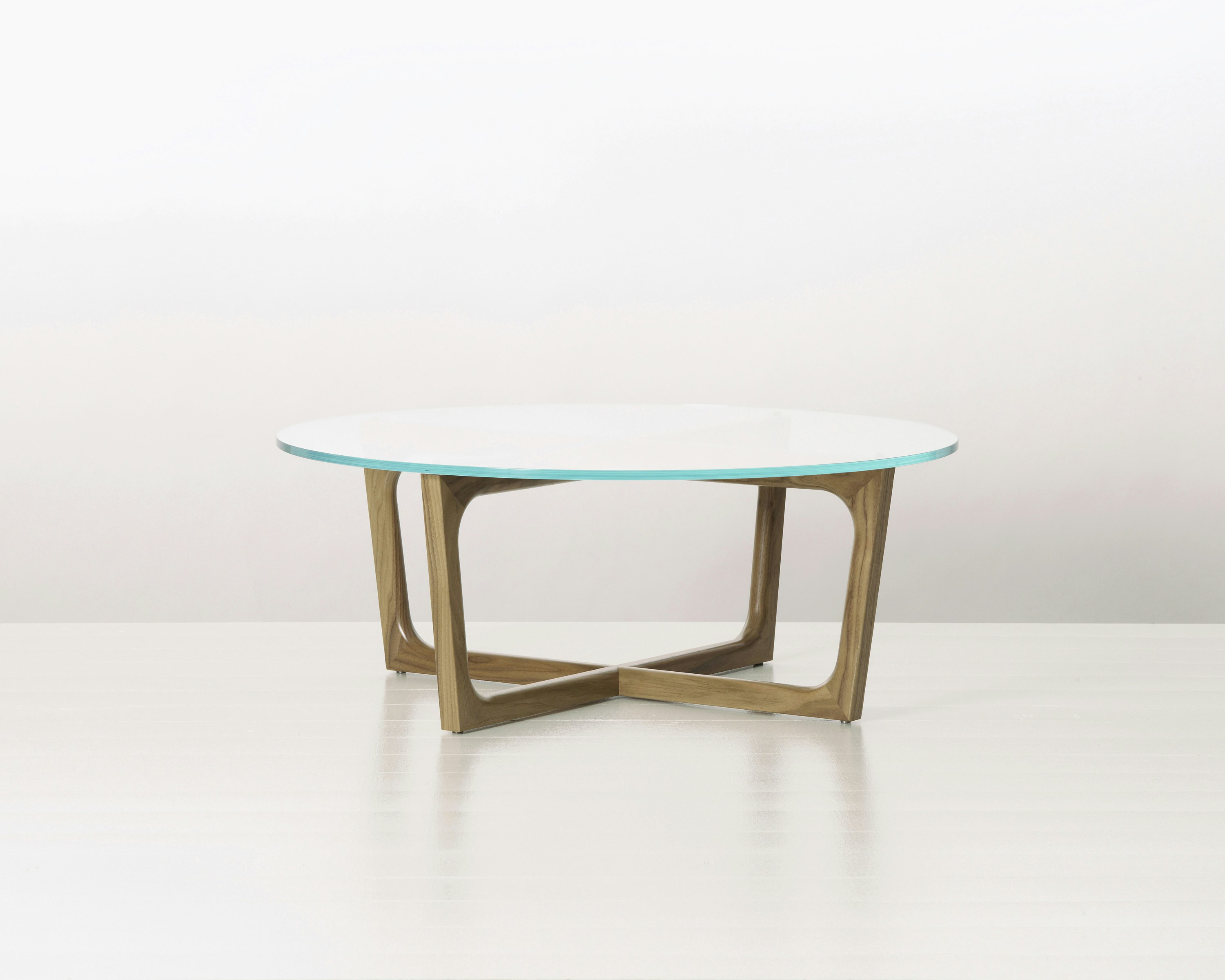 A round Loophole coffee table with a glass top and a walnut base.