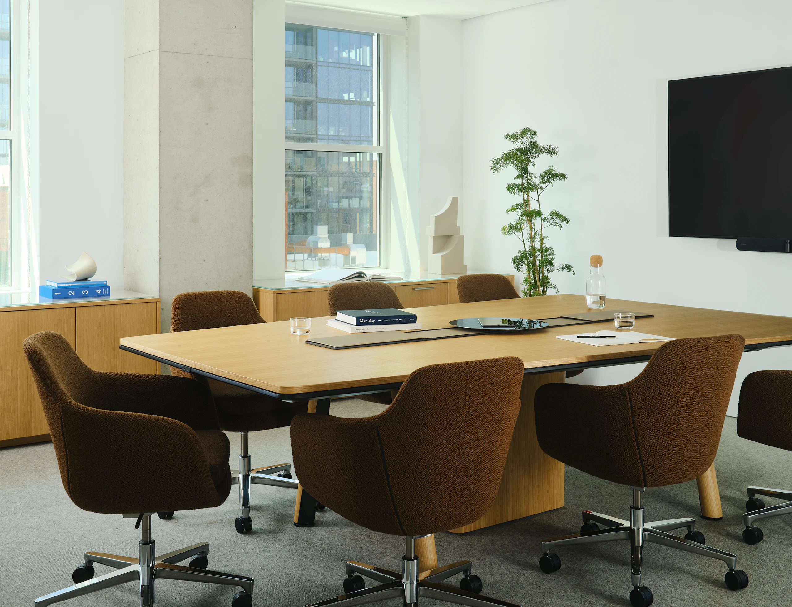 Ascent Conference Table designed by EOOS for DatesWeiser in Natural Rift Cut Oak with a trapezoid top shown at an angle surrounded by Geiger Saiba chairs and two JD Credenzas