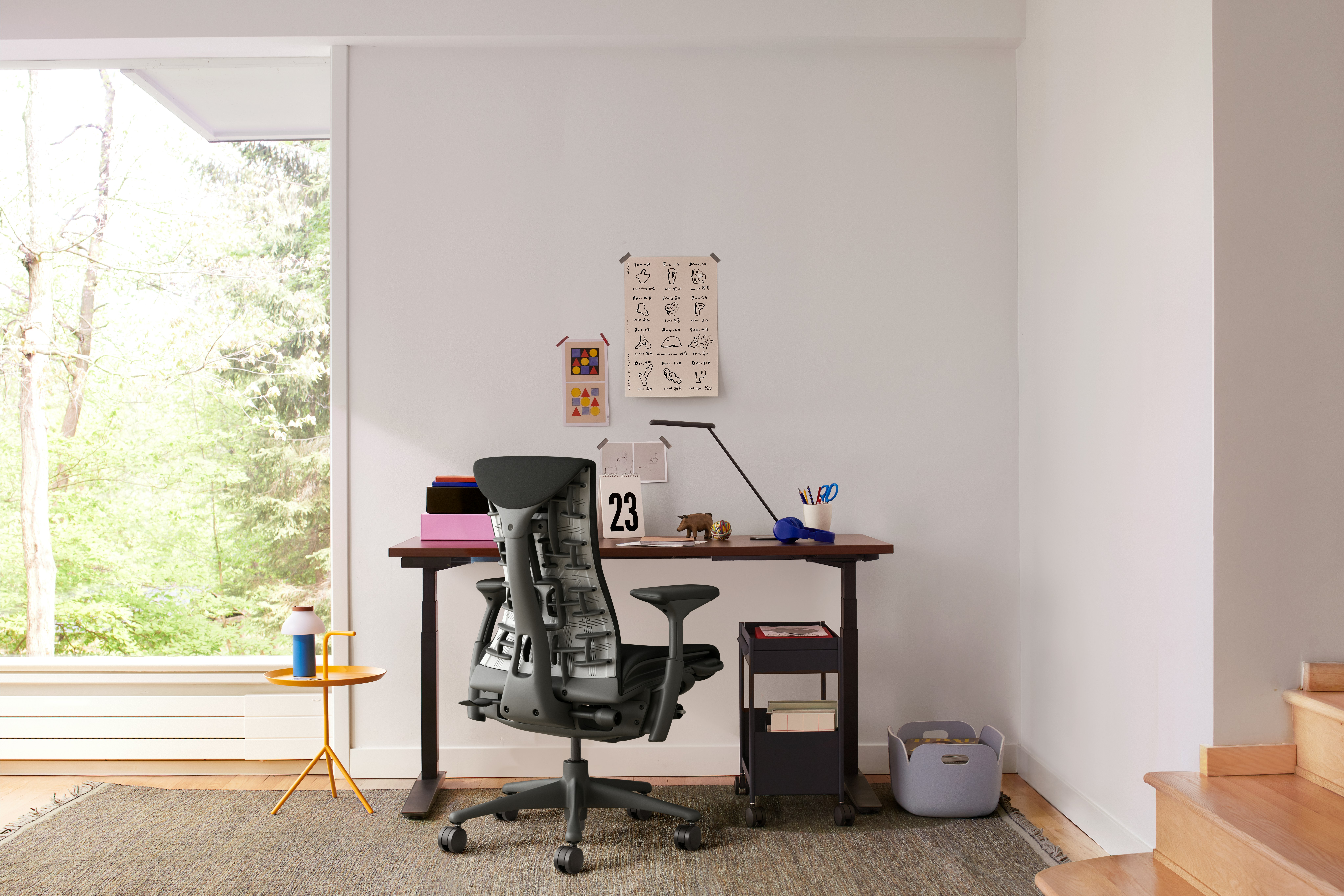 A black graphite Herman Miller Embody Office Chair at a Jarvis laminate Sit-Stand Desk, featuring an OE1 Storage Trolley and HAY PC Portable Lamp.
