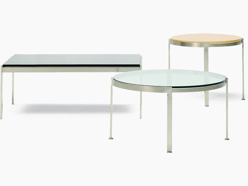 A round Metal Series side table with a wood top in the background and a round Metal Series coffee table in the foreground.