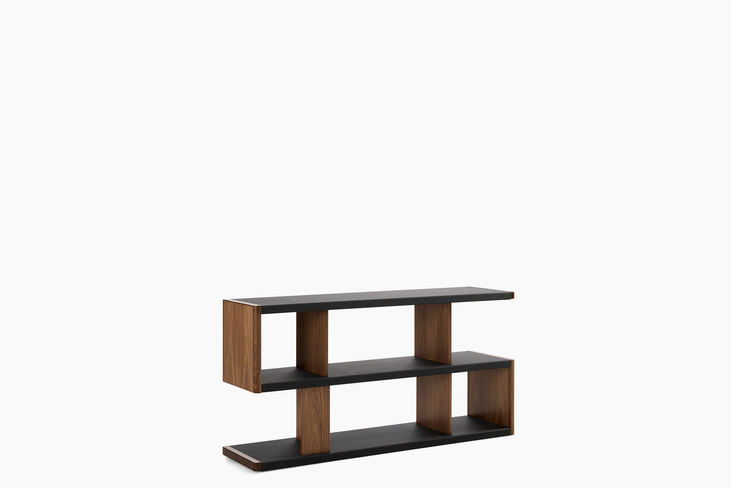 New Canaan Low Bookshelf designed by BassamFellows for Geiger in Walnut with Black Leather shown angled on a white sweep.