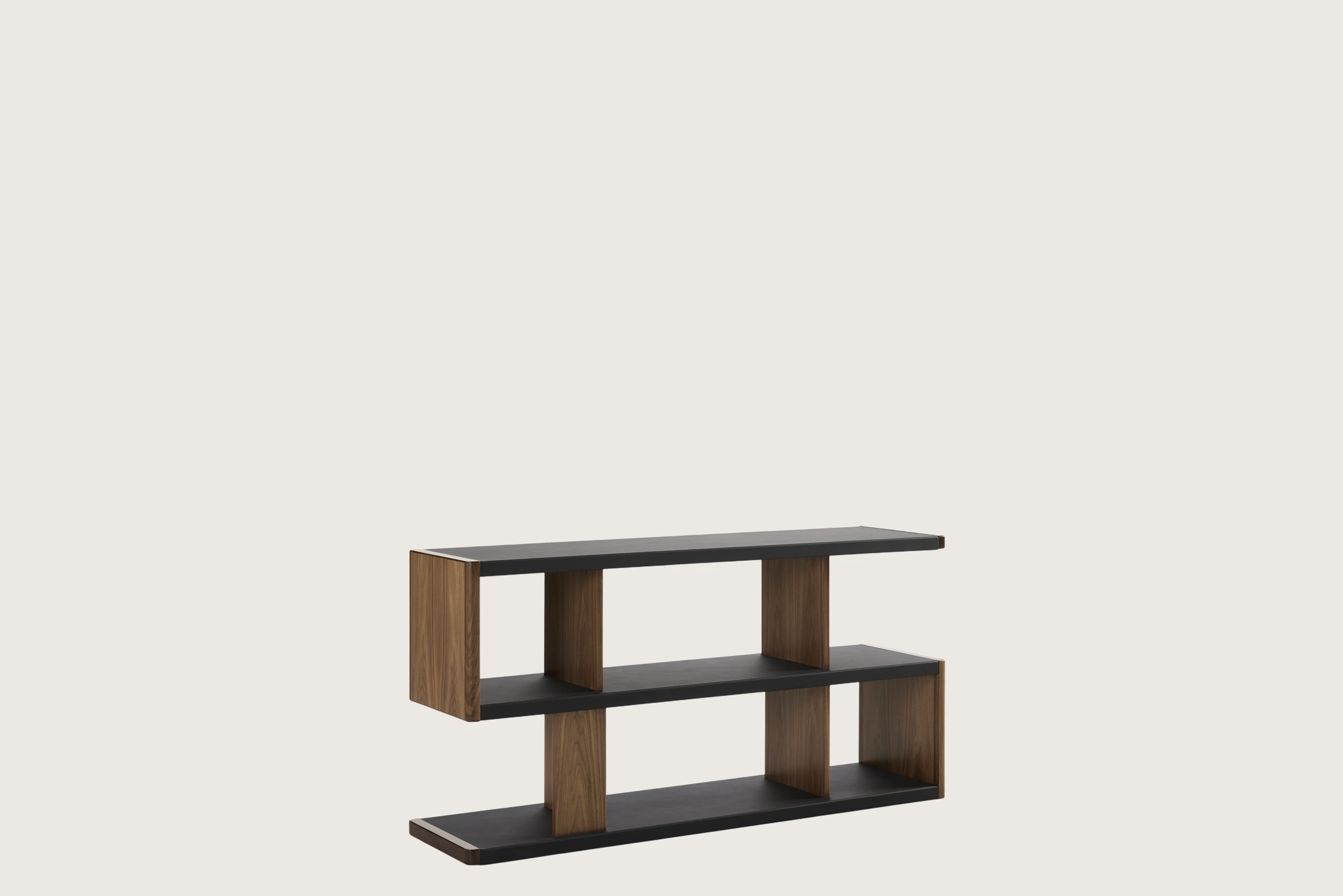 New Canaan Low Bookshelf designed by BassamFellows for Geiger in Walnut with Black Leather shown angled on a white sweep.