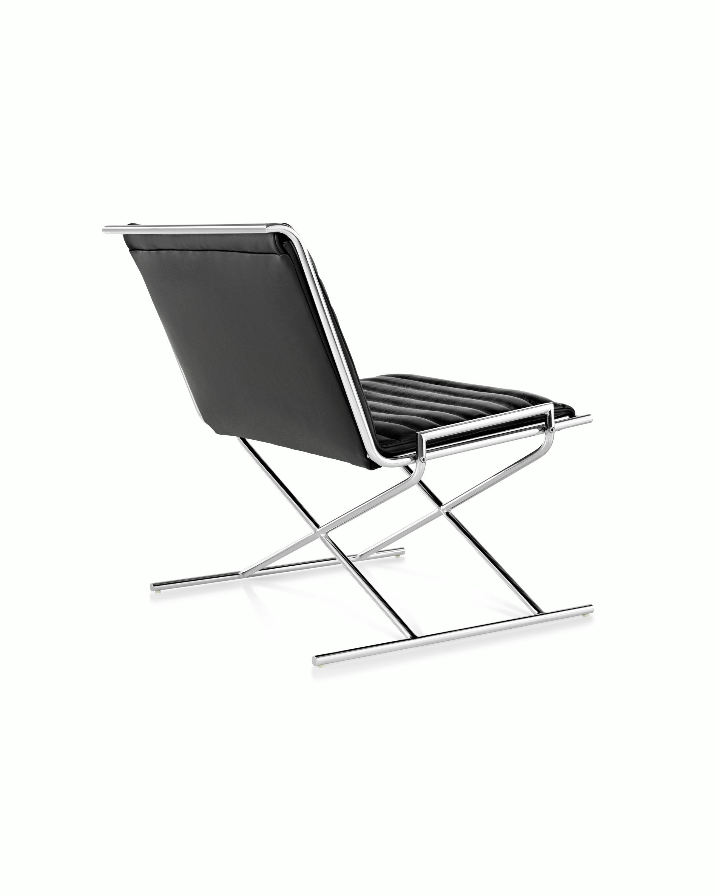 A Sled lounge chair with ribbed black leather upholstery and an X-shaped steel frame, viewed from behind at an angle.