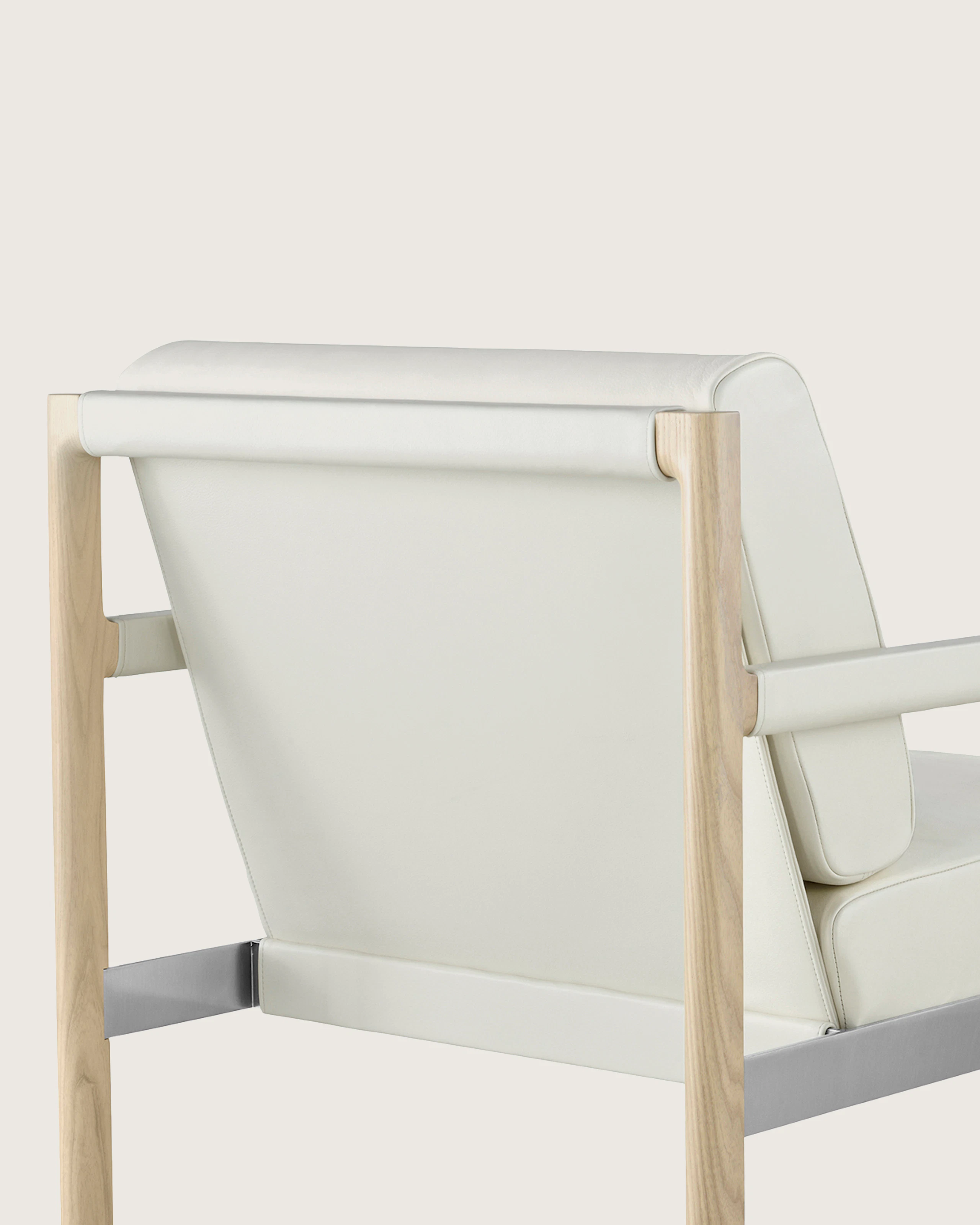 A Brabo club chair with off-white leather upholstery, viewed from behind to show the exposed wood and metal frame.