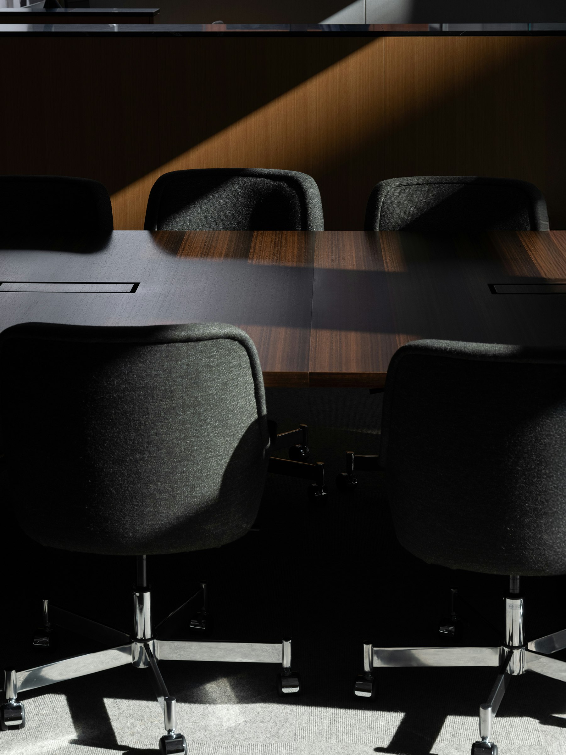 Bumper Conference Chairs with low arms upholstered with Bellano Black Green around a JD Conference Table in Fumed Quarter Cut Eucalyptus.