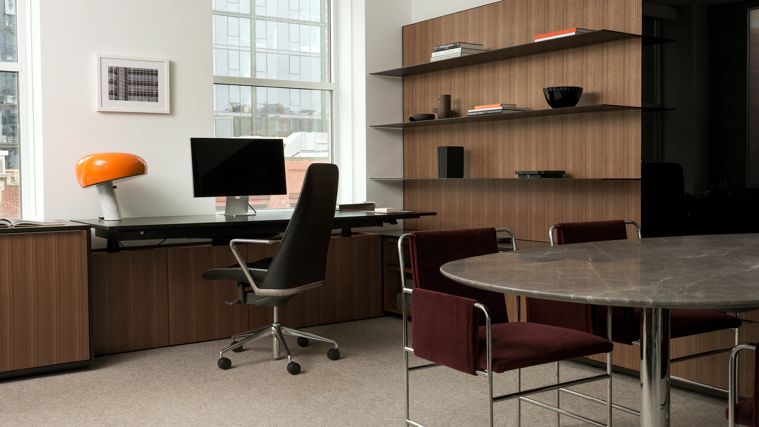 Geiger One Private Office in Natural Quarter Cut Walnut with a Taper Chair, MP Table, and two Envelope Chairs, viewed at an angle.