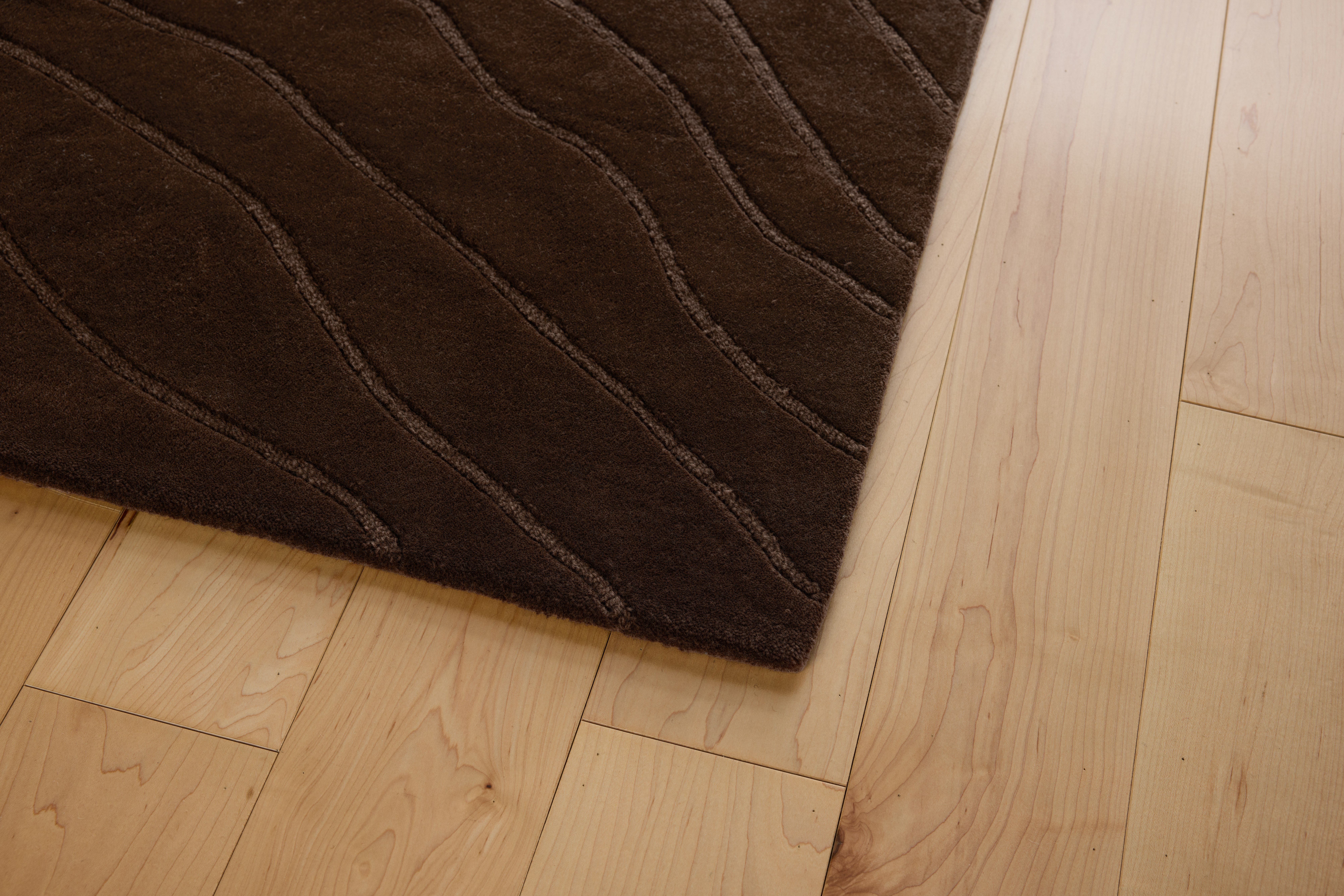 A detailed look at a Waves Rug in Chestnut.