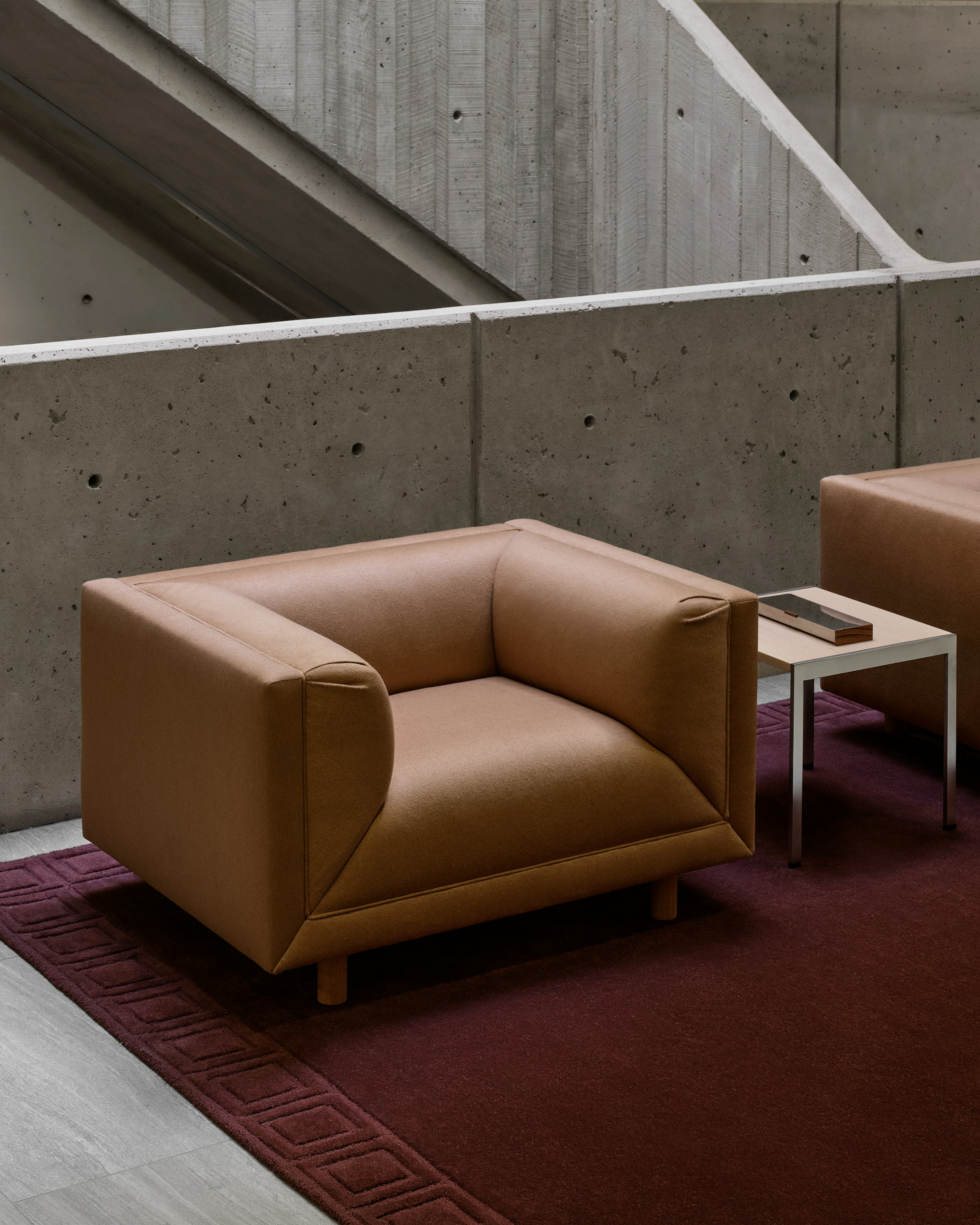 Two Rolled Arm Sofas upholstered with Brushed Camel in Natural with an H Frame Side Table with a Nordic Oak top and chrome frame between them, viewed at an angle on a burgundy rug.