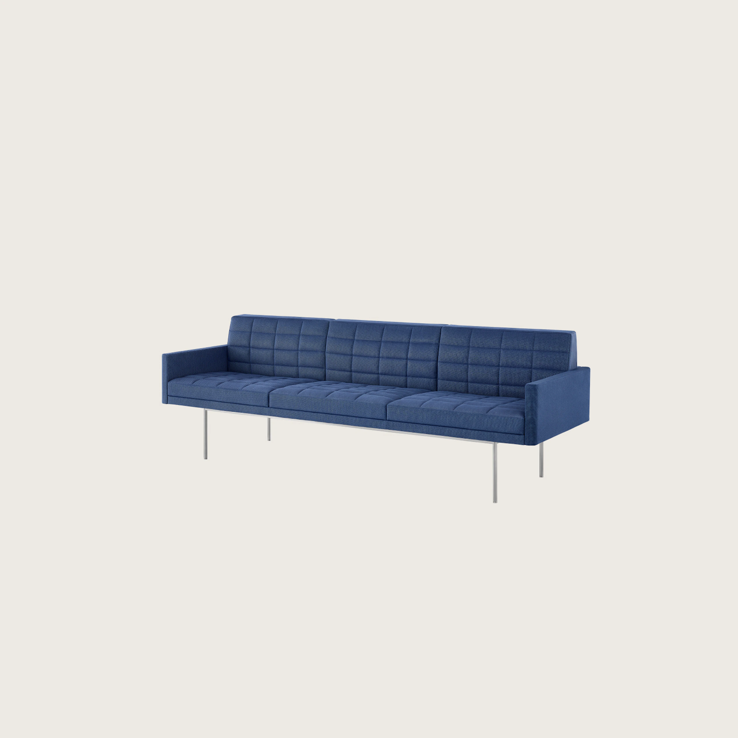 Angled view of a quilted Tuxedo Component sofa upholstered in blue fabric.