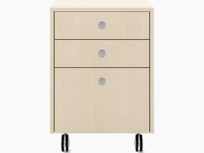 Sled Base Mobile Pedestal in ash with three drawers and chrome pulls on casters viewed from the font.