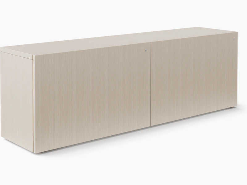 A credenza with closed front doors is viewed in a light veneer.