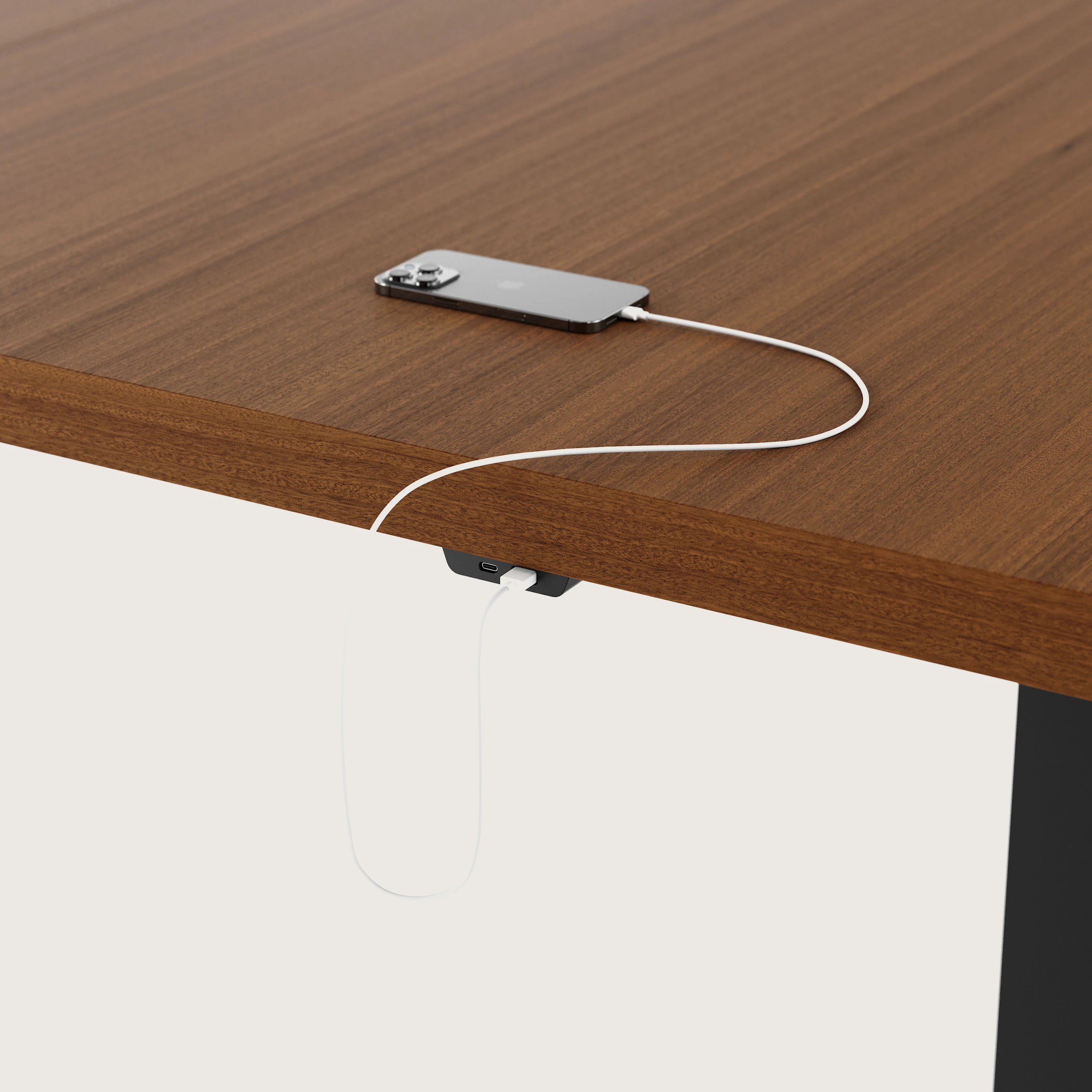 Detail shot of undermount power access on a rectangular JD Conference Table with a Natural Quarter Cut Walnut tabletop and Black base.
