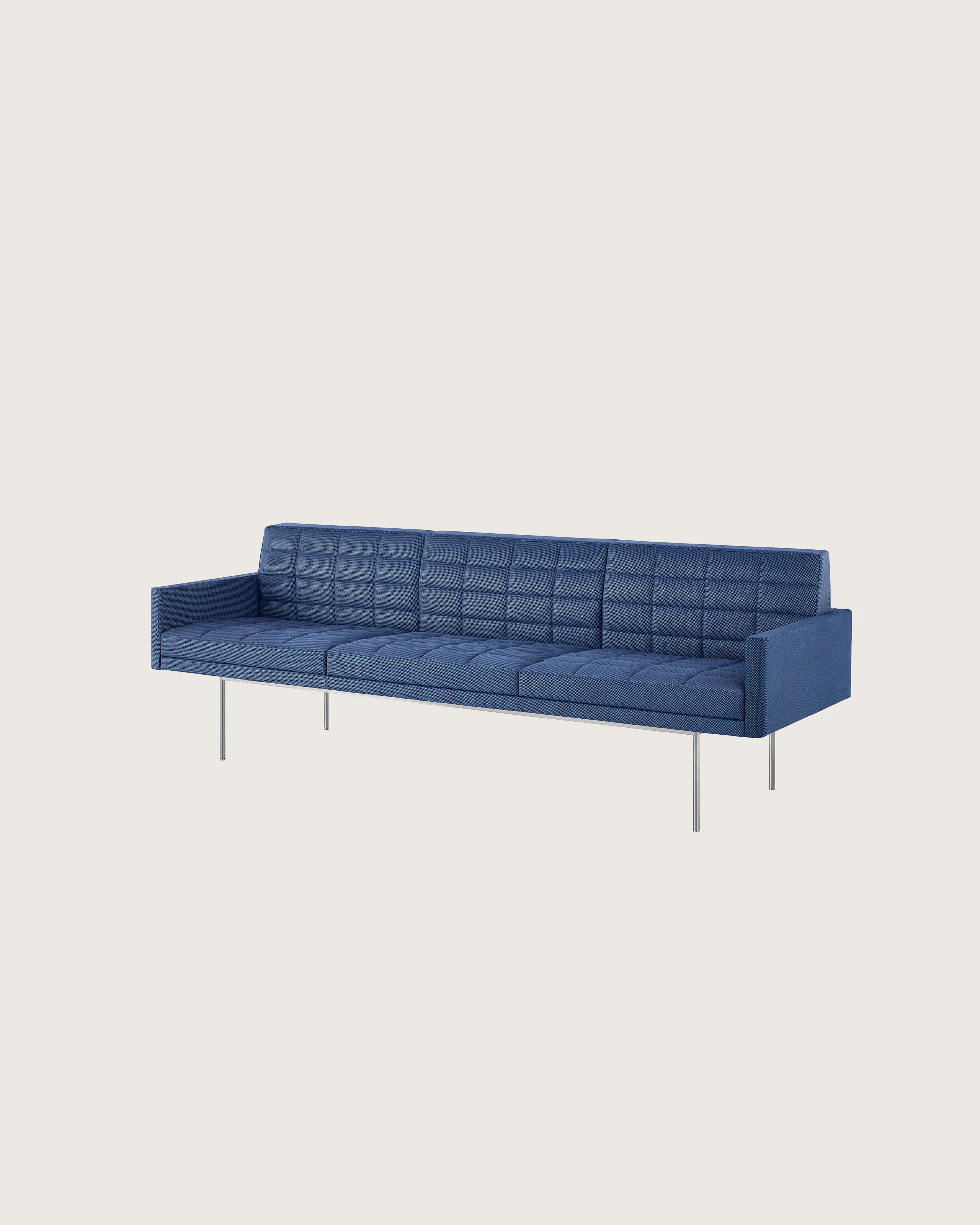 Angled view of a quilted Tuxedo Component sofa upholstered in blue fabric.