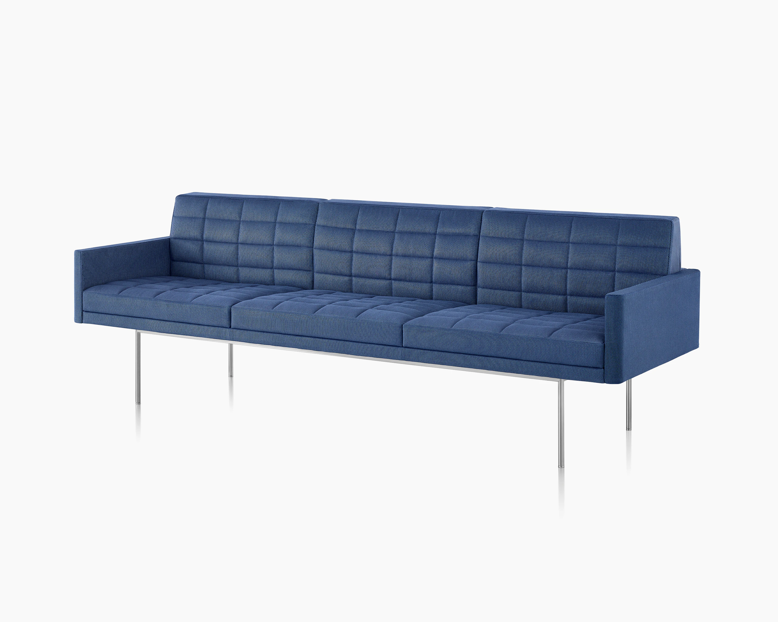 Angled view of a quilted Tuxedo Component sofa upholstered in blue fabric.