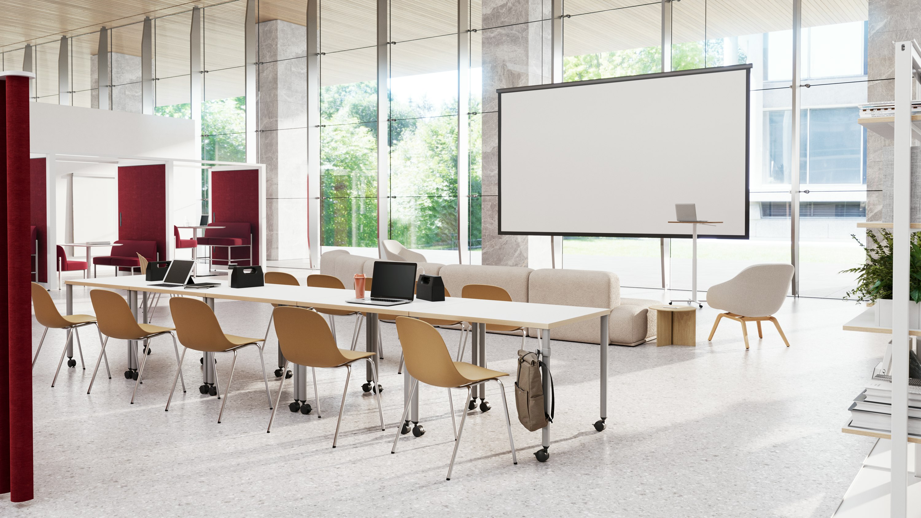Communal working area in a higher education setting furnished with several white OE1 Project Tables, yellow side chairs, and an additional seating area with projector screen.