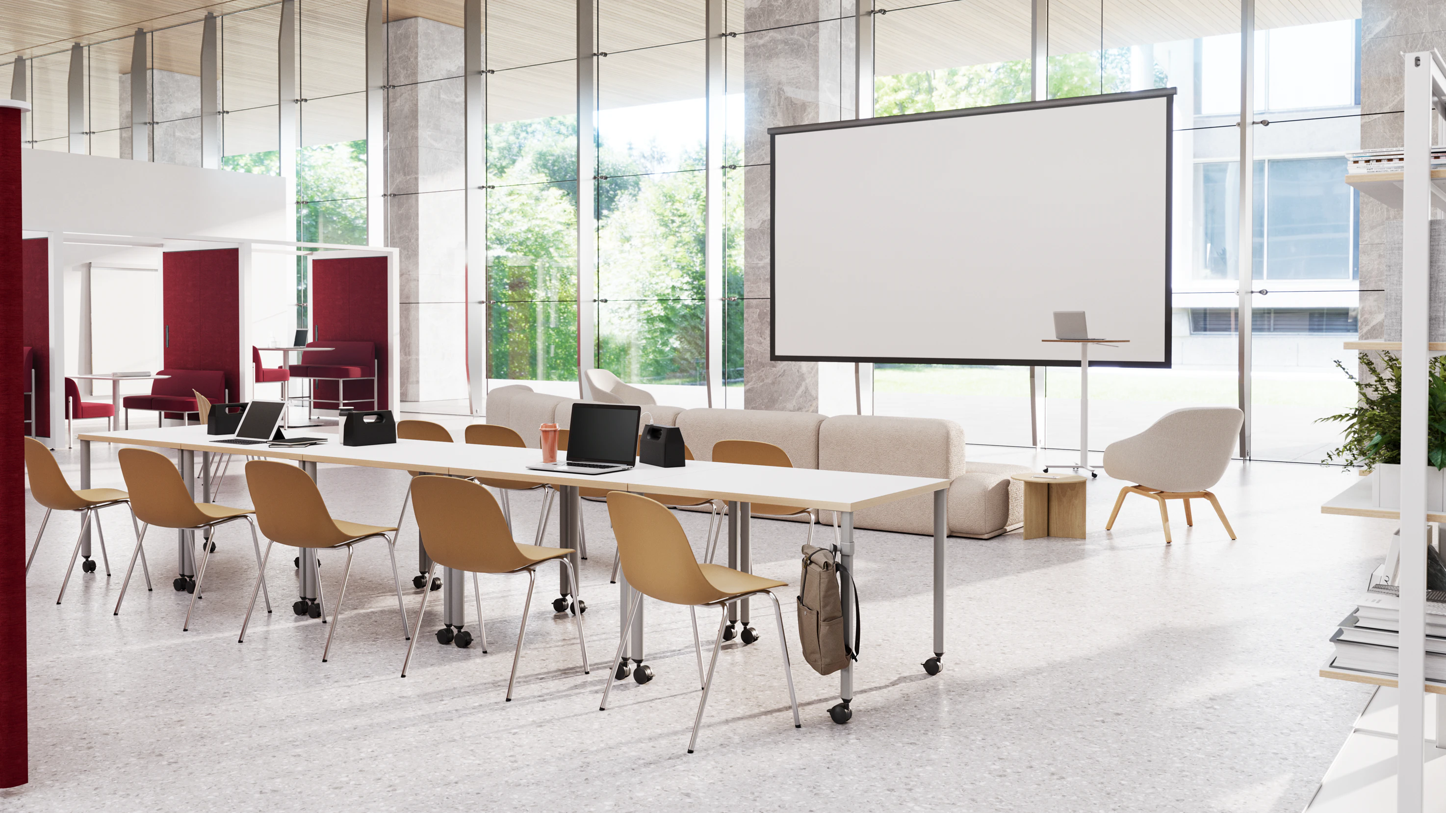 Communal working area in a higher education setting furnished with several white OE1 Project Tables, yellow side chairs, and an additional seating area with projector screen.