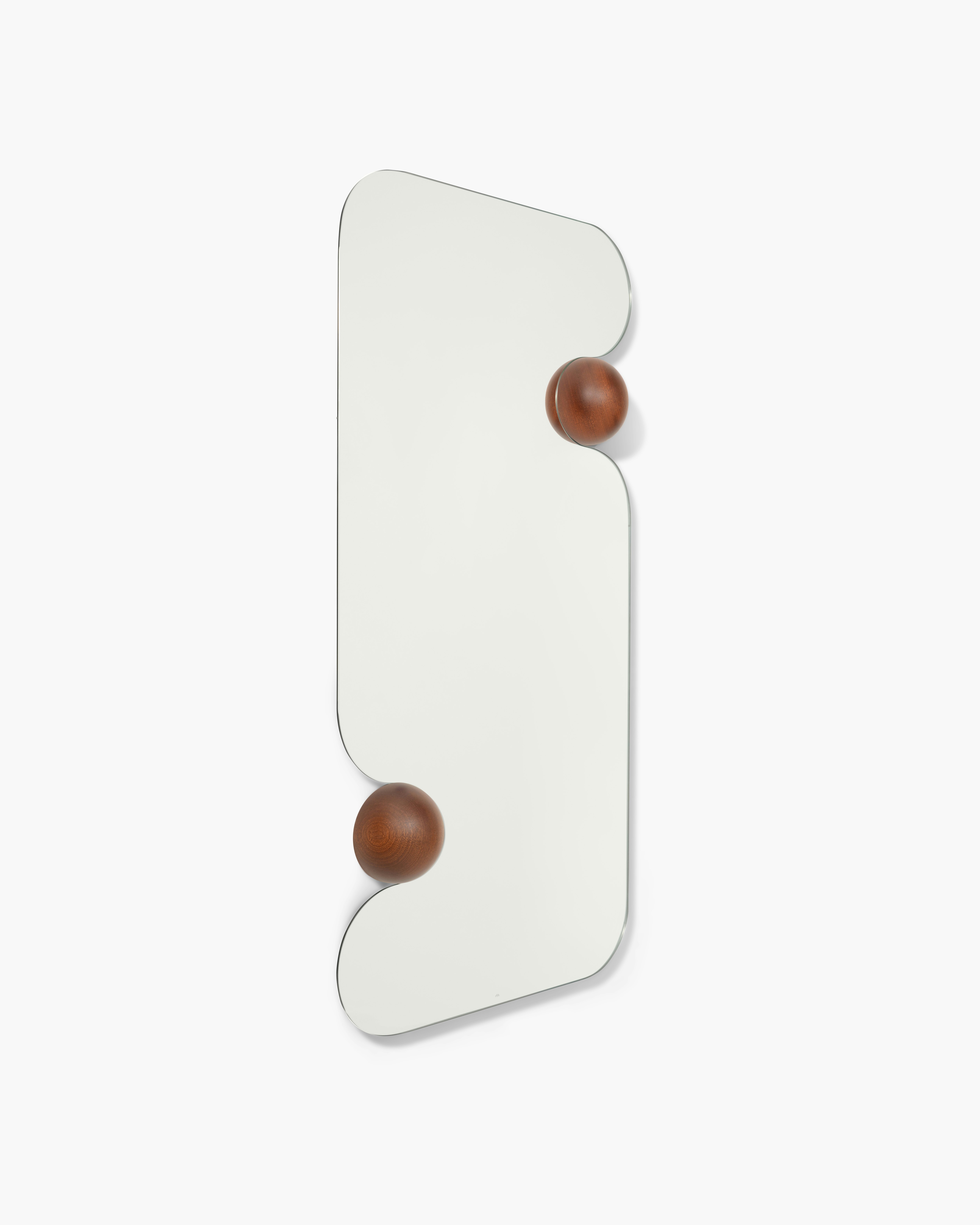 A Squeeze Mirror in Walnut viewed from an angle.