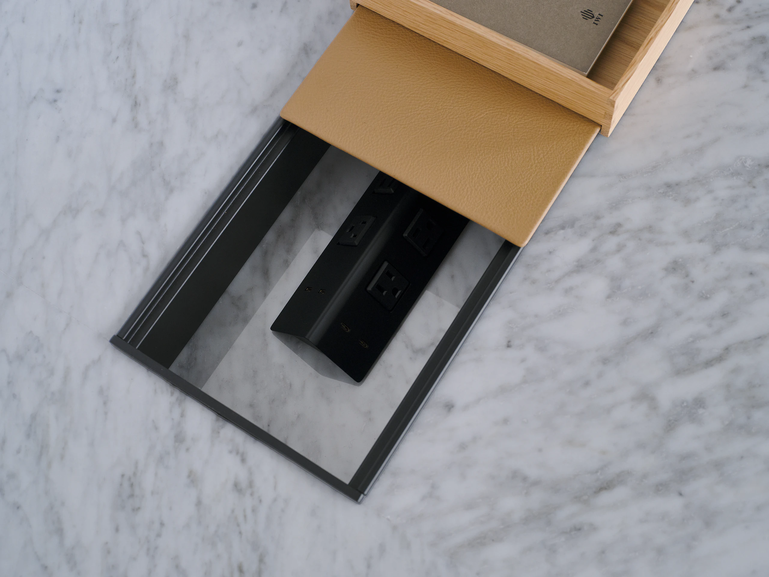 scent Conference Table, designed by EOOS for DatesWeiser, shown in White Carrara Marble with power troughs partially covered with Prone leather in Meander, viewed from above as a detail shot.