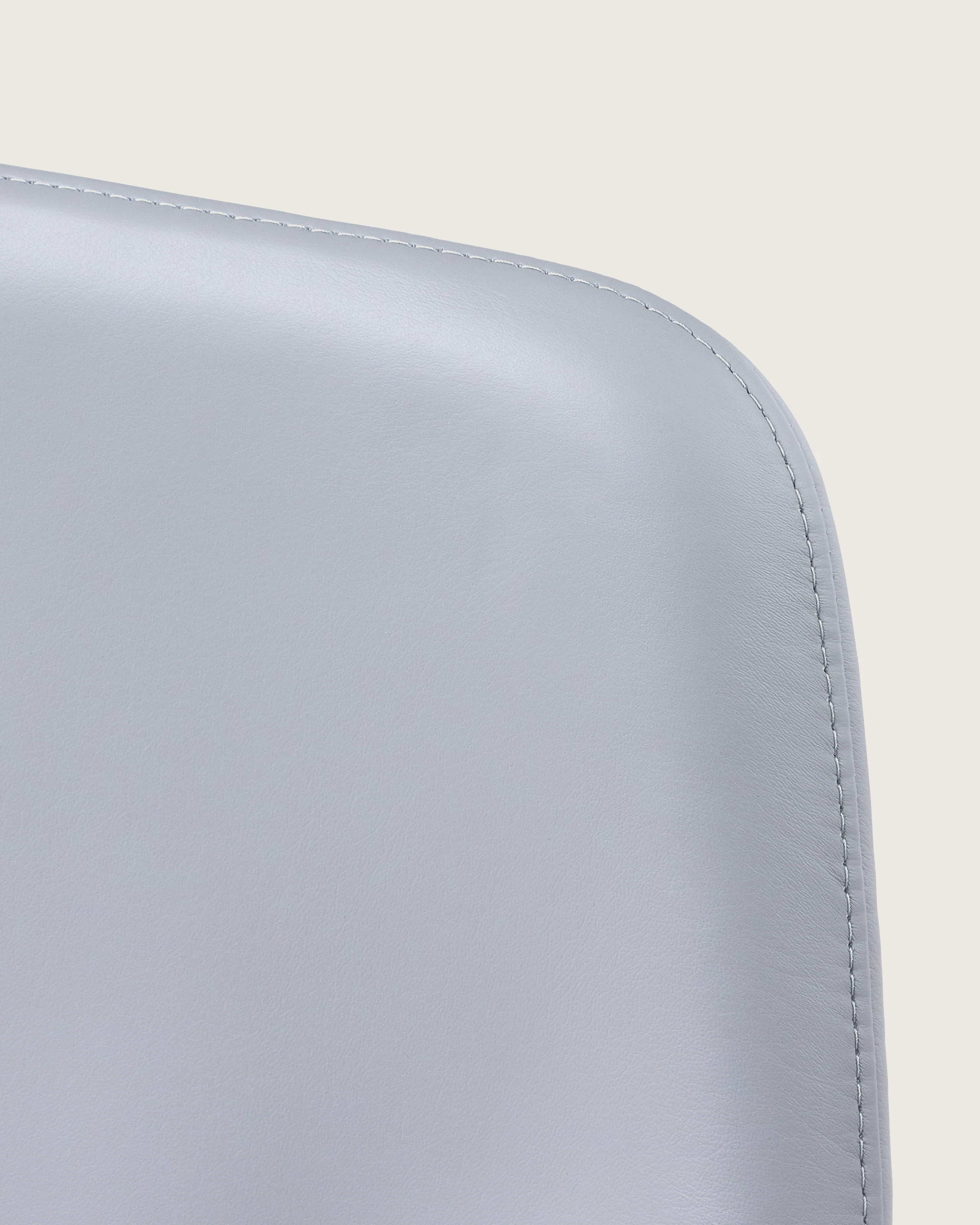 Close-up of an upper corner on the back of a Taper office chair, showing the single stitch option.