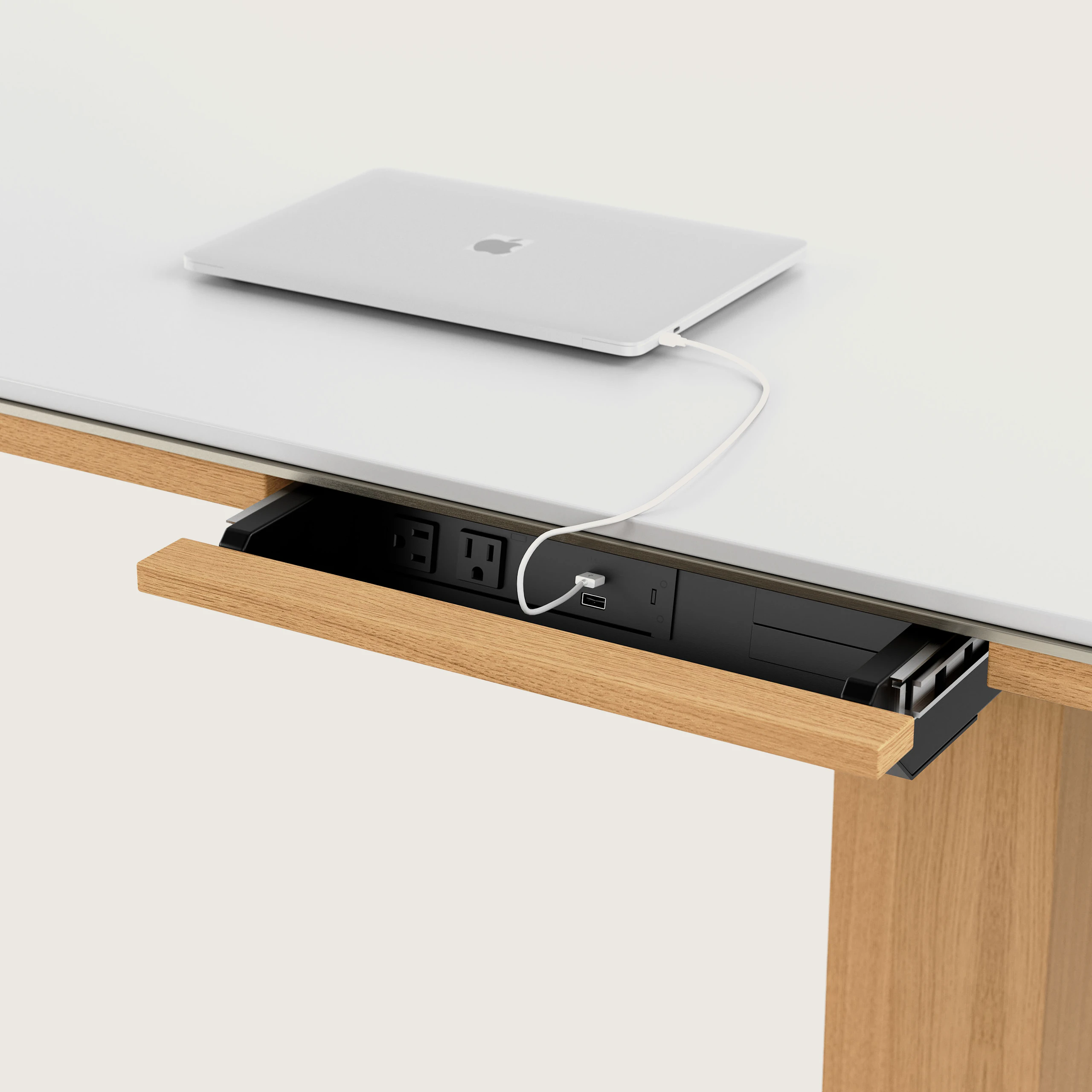 Detail shot of open power drawer on Highline Fifty Conference Table in Glacier White Corian and Natural Rift Cut Oak viewed from an angle.
