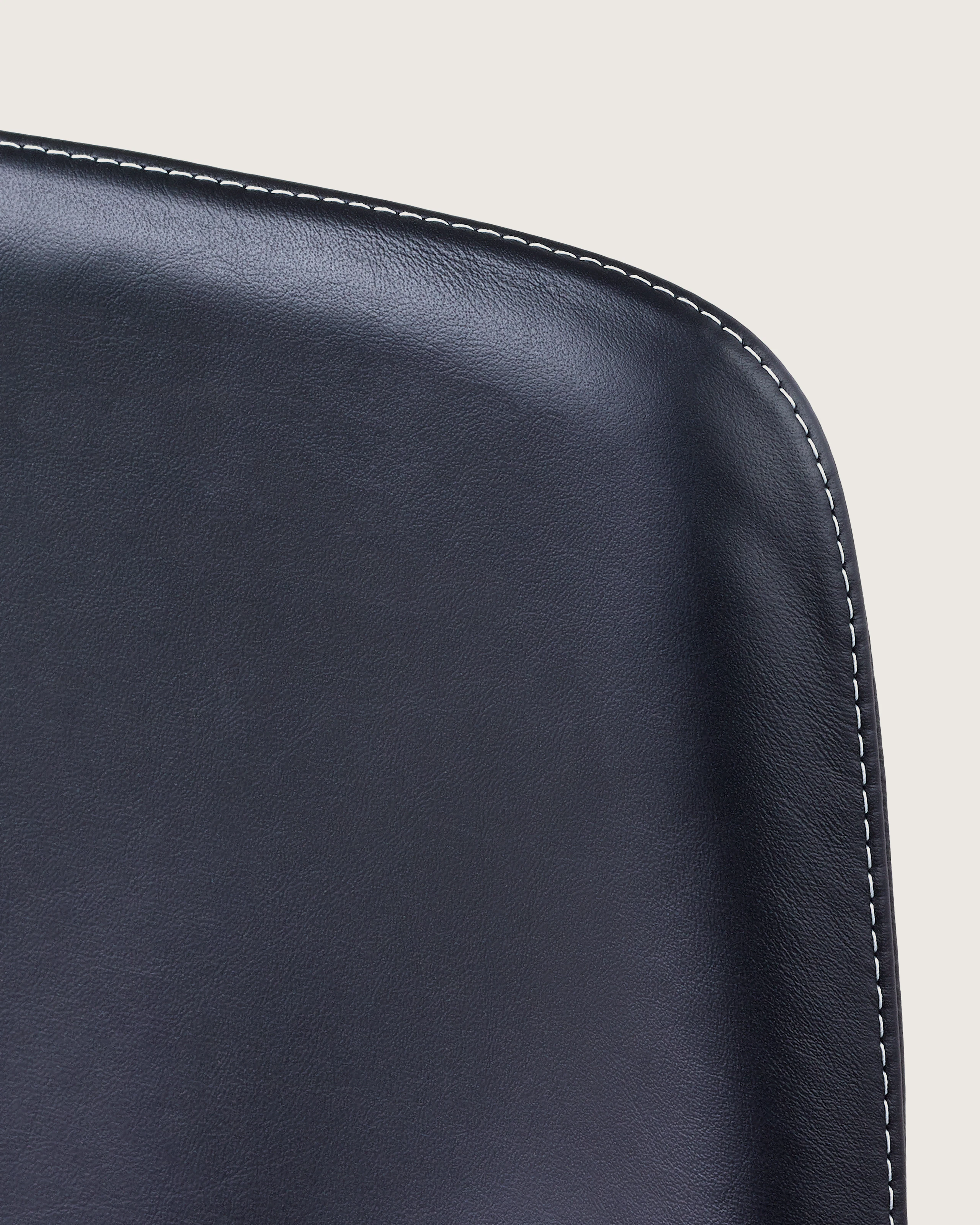 Close-up of an upper corner on the back of a Taper office chair, showing the single stitch option with constrasting thread.