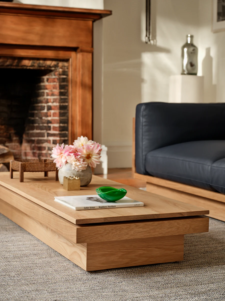 Coffee table with flowers and books in front of fireplace