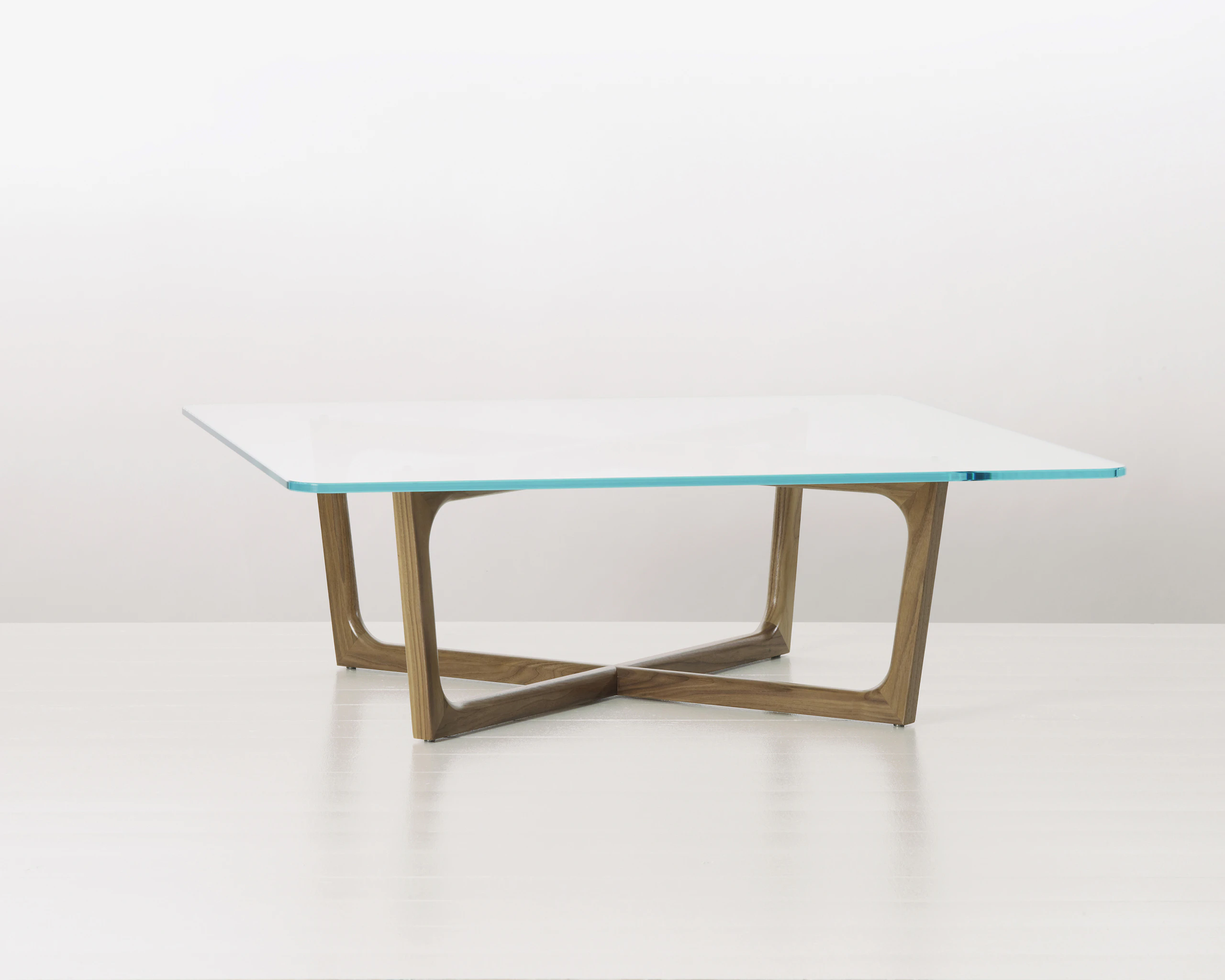 A square Loophole coffee table with a glass top and walnut base.