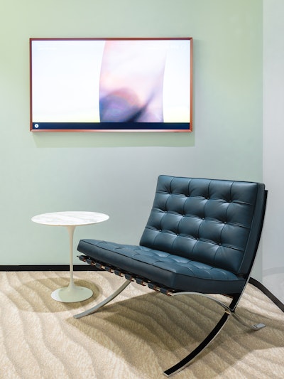 Close up of a Barcelona Chair with Saarinen Pedestal Table.
