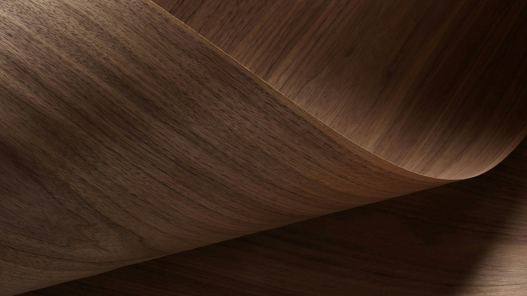 A dark brown veneer finish from the MillerKnoll Central Palette sloping upwards in a wave-like shape.