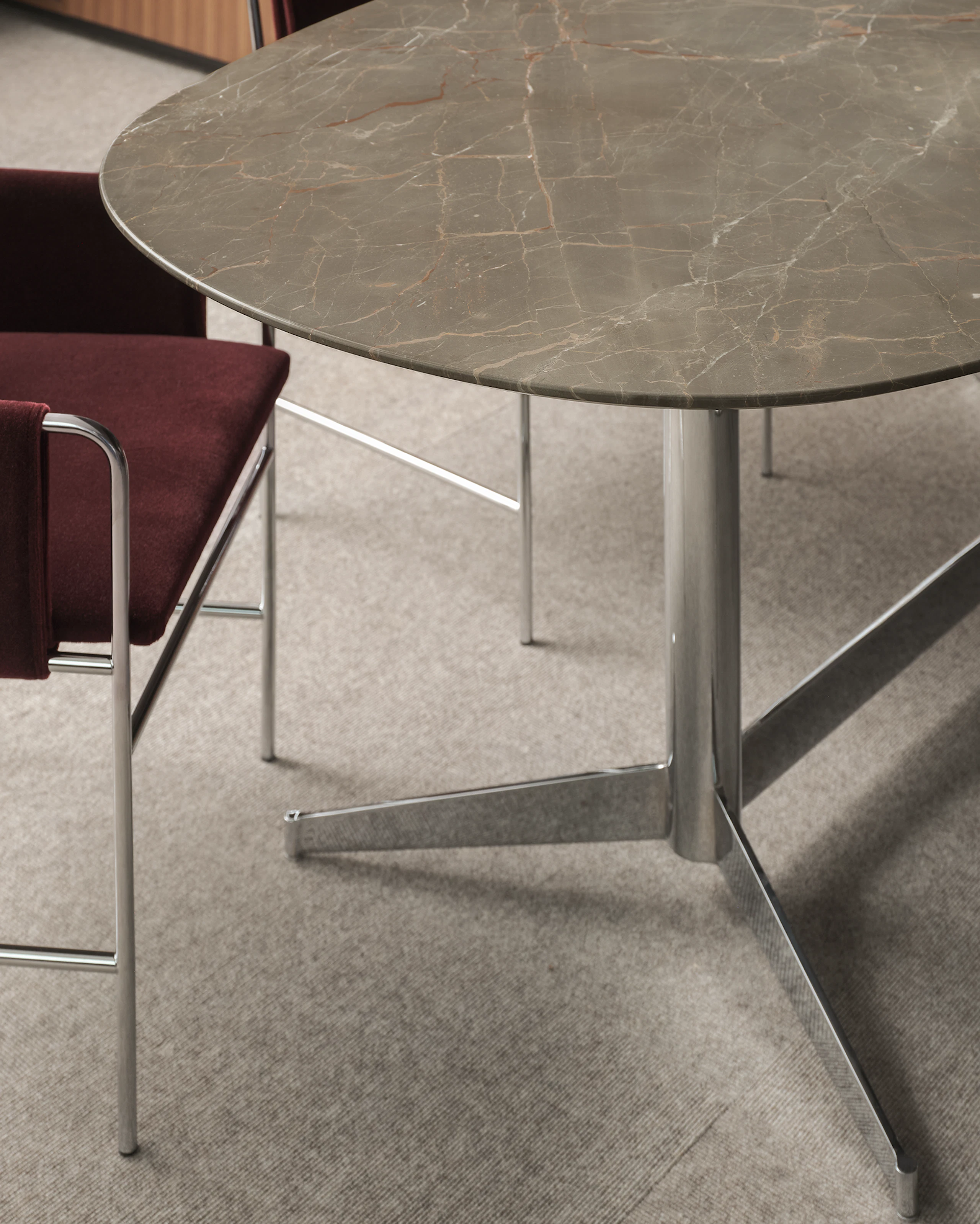 MP Table in Ombra di Caravaggio Marble with a chrome base with two Envelope Chairs upholstered with Knoll Velvet in Wine with chrome frames, viewed at an angle.