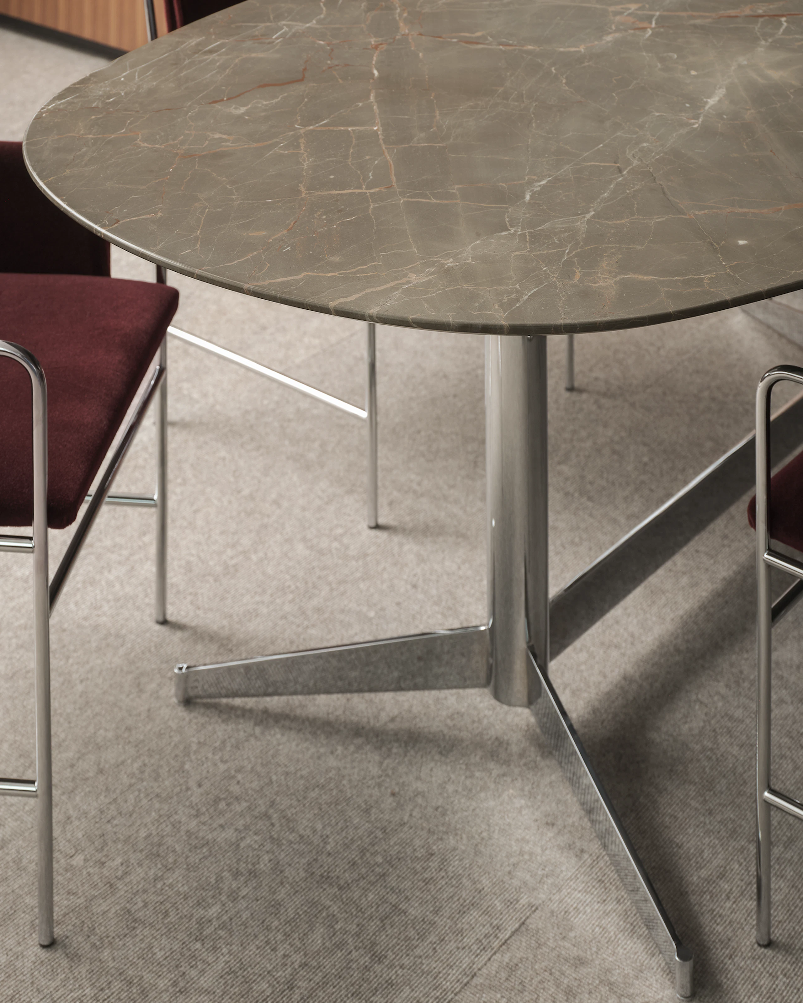 MP Table in Ombra di Caravaggio Marble with a chrome base with two Envelope Chairs upholstered with Knoll Velvet in Wine with chrome frames, viewed at an angle.