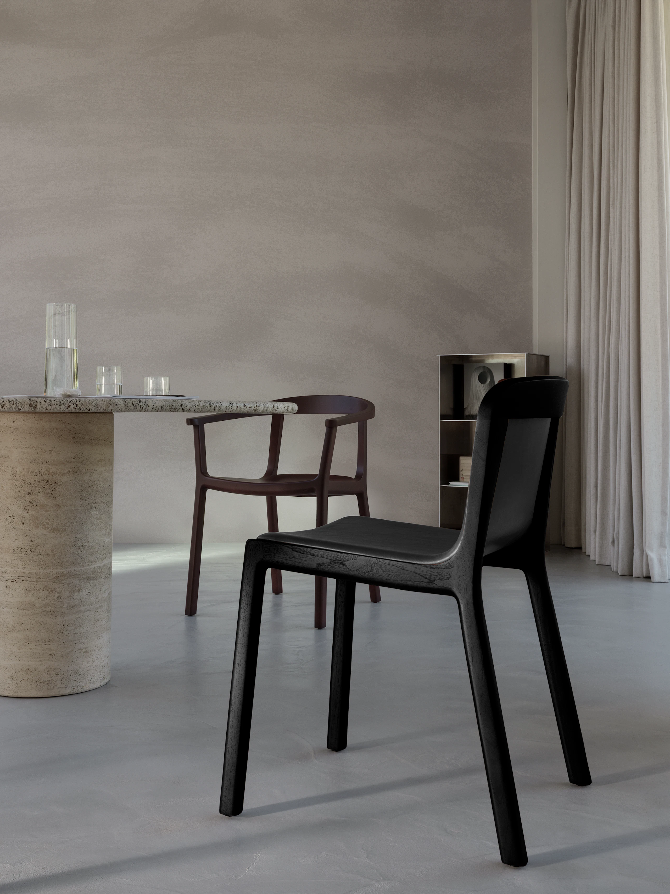 Lijn Side Chair in Ebonized Oak fully upholstered with black leather, viewed from behind at an angle next to a dining room table with a Lijn Armchair in the background, in a residential setting.