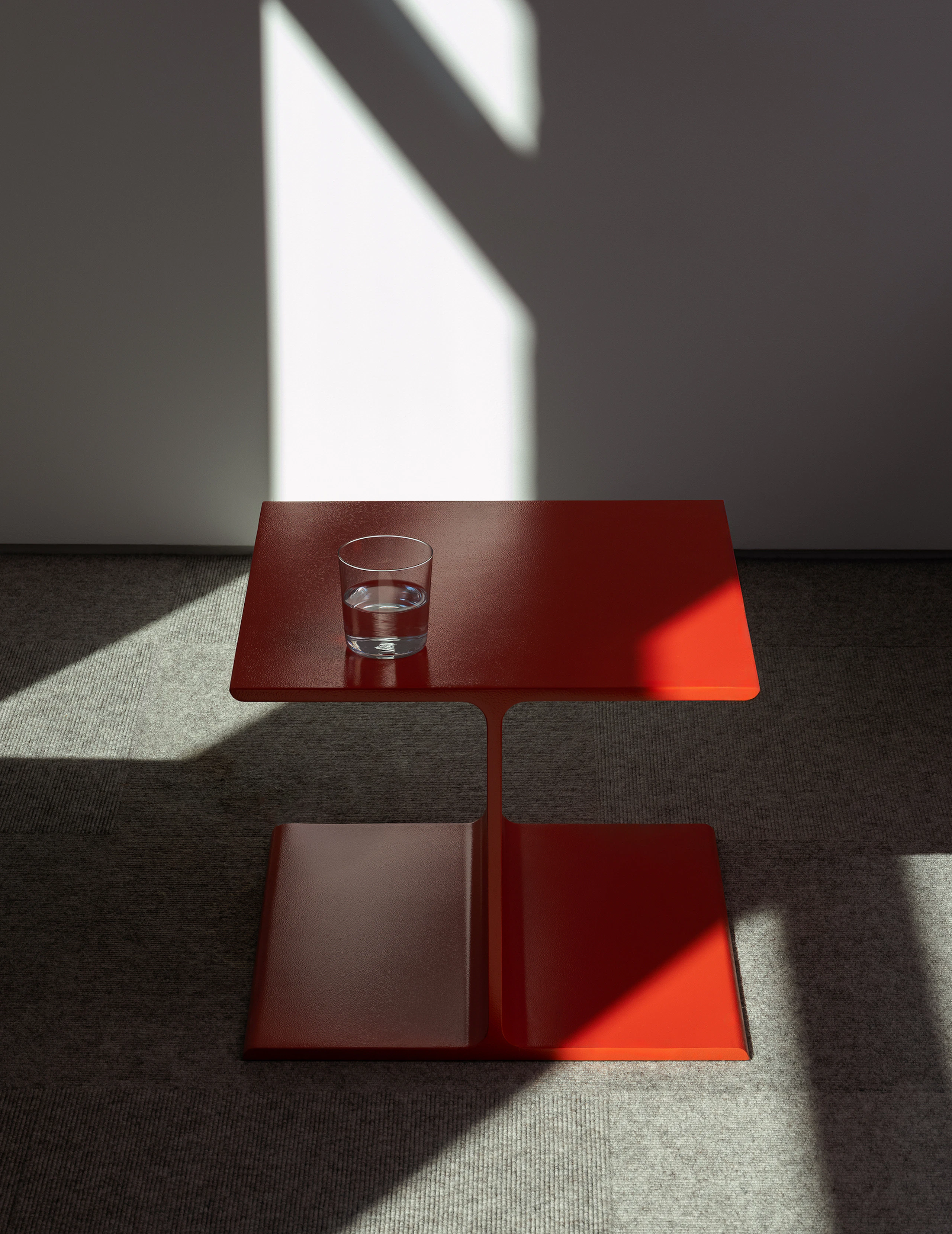 I Beam Side Table in International Orange designed by Ward Bennett, viewed from the front in an office setting.