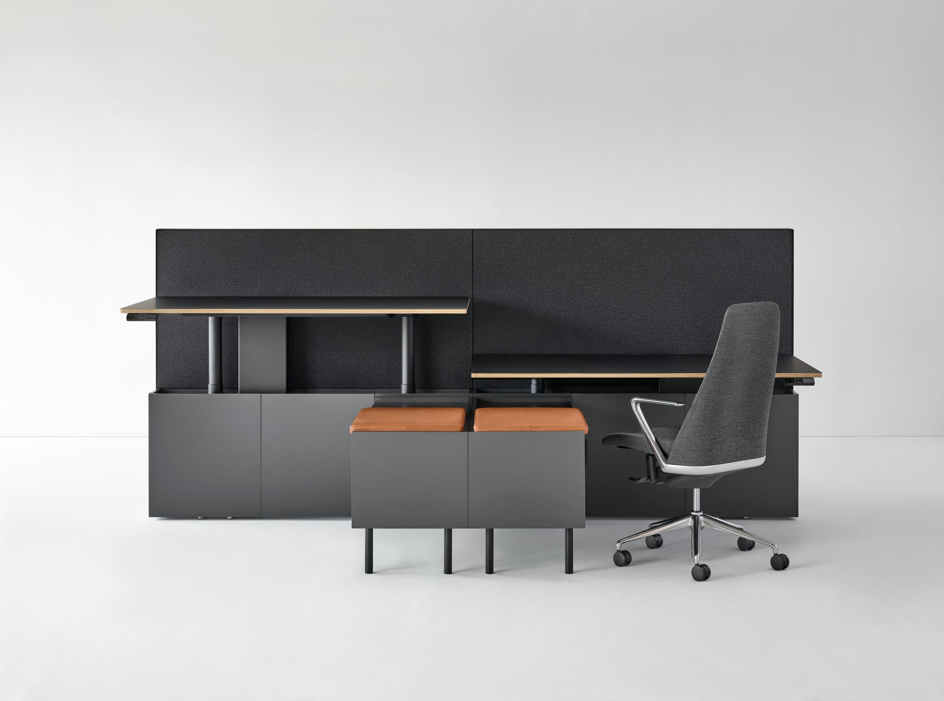 A two-pack Geiger One Casegoods bench system. One workstation is at standing height while the other is at sitting height with a Taper Chair.