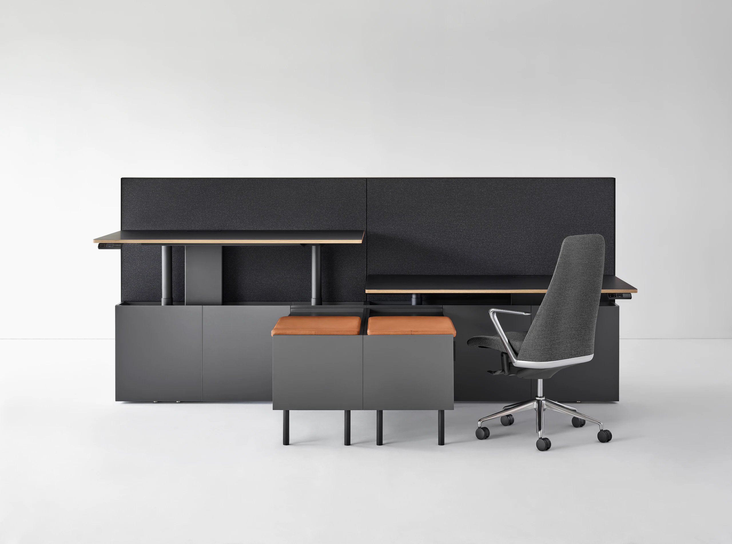 A two-pack Geiger One Casegoods bench system. One workstation is at standing height while the other is at sitting height with a Taper Chair.