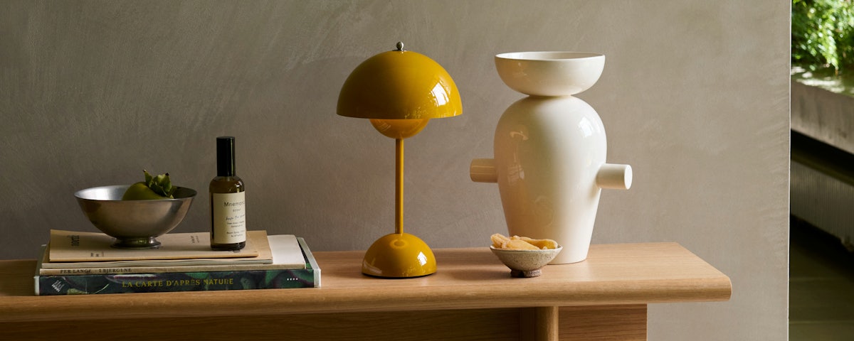 VP9 Flowerpot Portable Lamp on a console table with various accessories