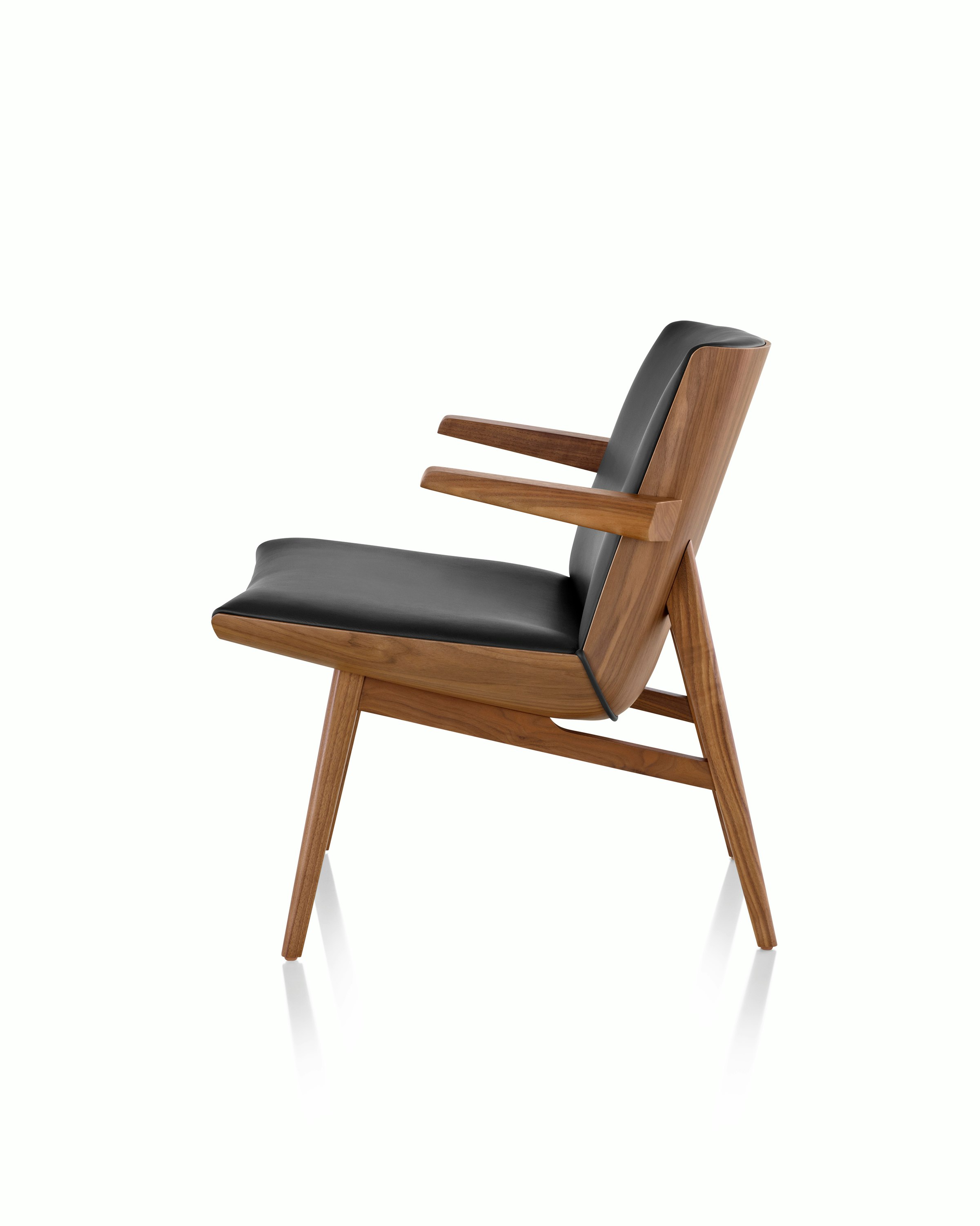 Side view of a low-back Clamshell Lounge Chair with black leather and walnut legs.