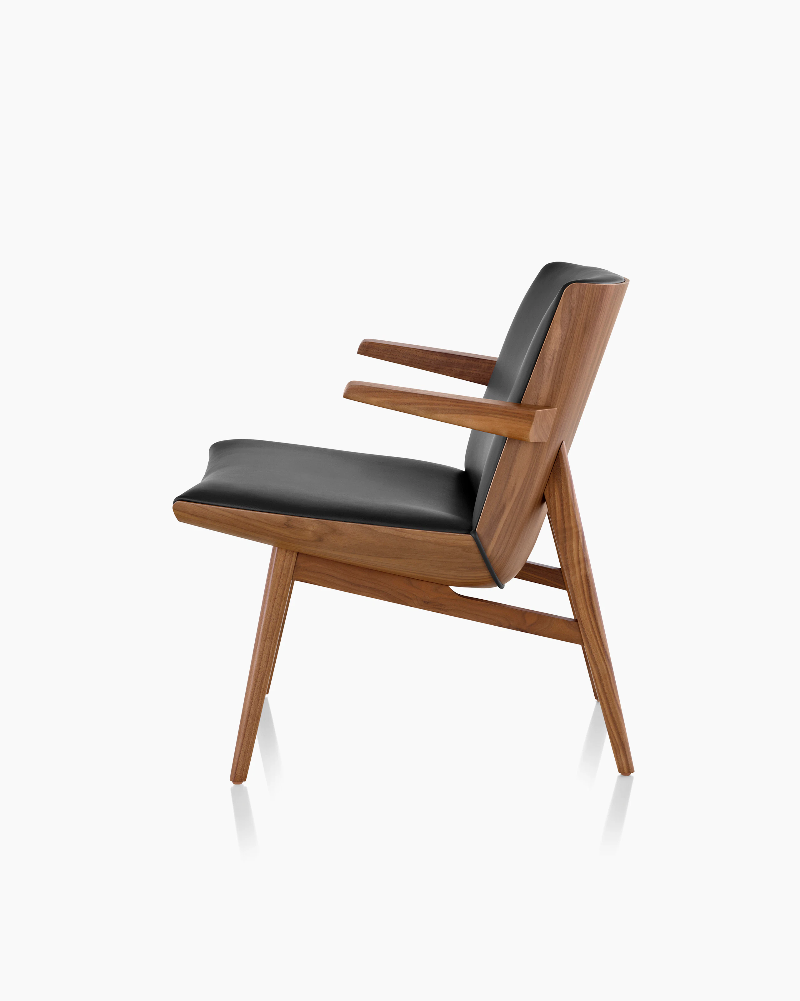 Side view of a low-back Clamshell Lounge Chair with black leather and walnut legs.