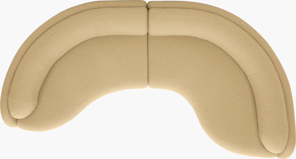Top-down view of beige curved sofa sections forming a heart-like shape