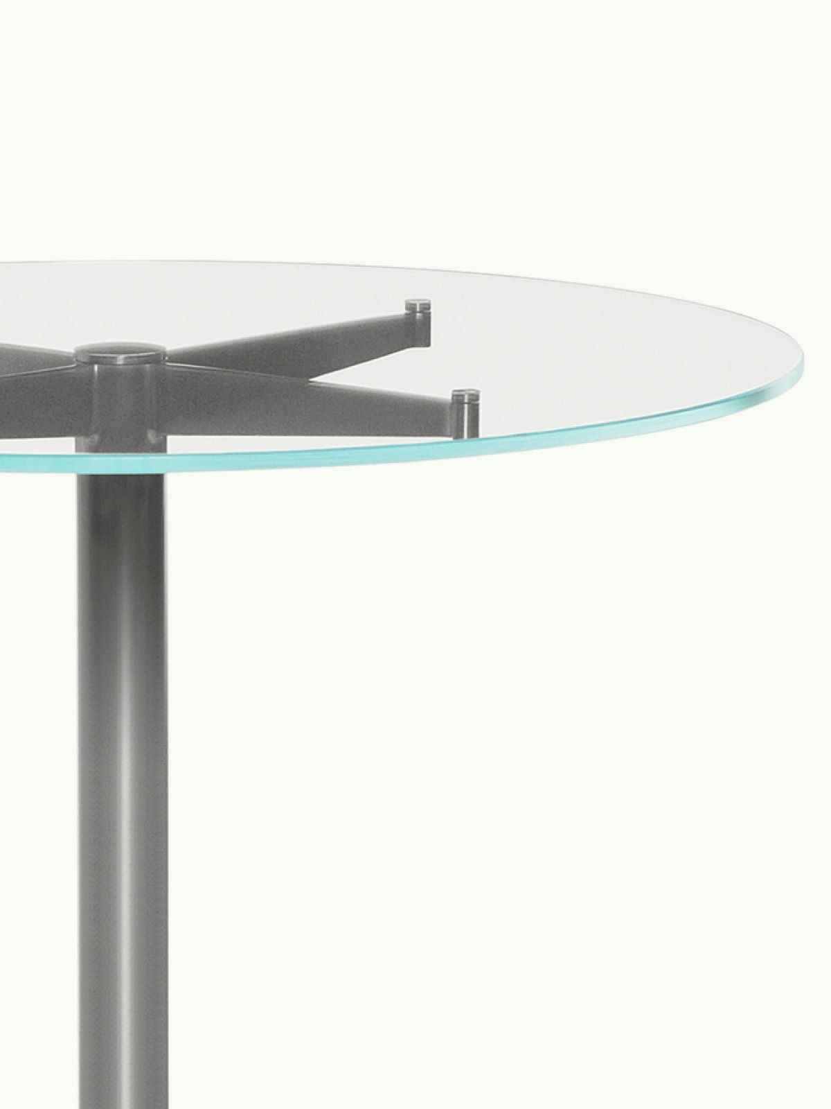 Close-up of the upper portion of an MP Occasional Table; showing a round glass top.