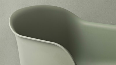 A close-up shot of the Fiber Armchair by Muuto in a dusty green colorway.